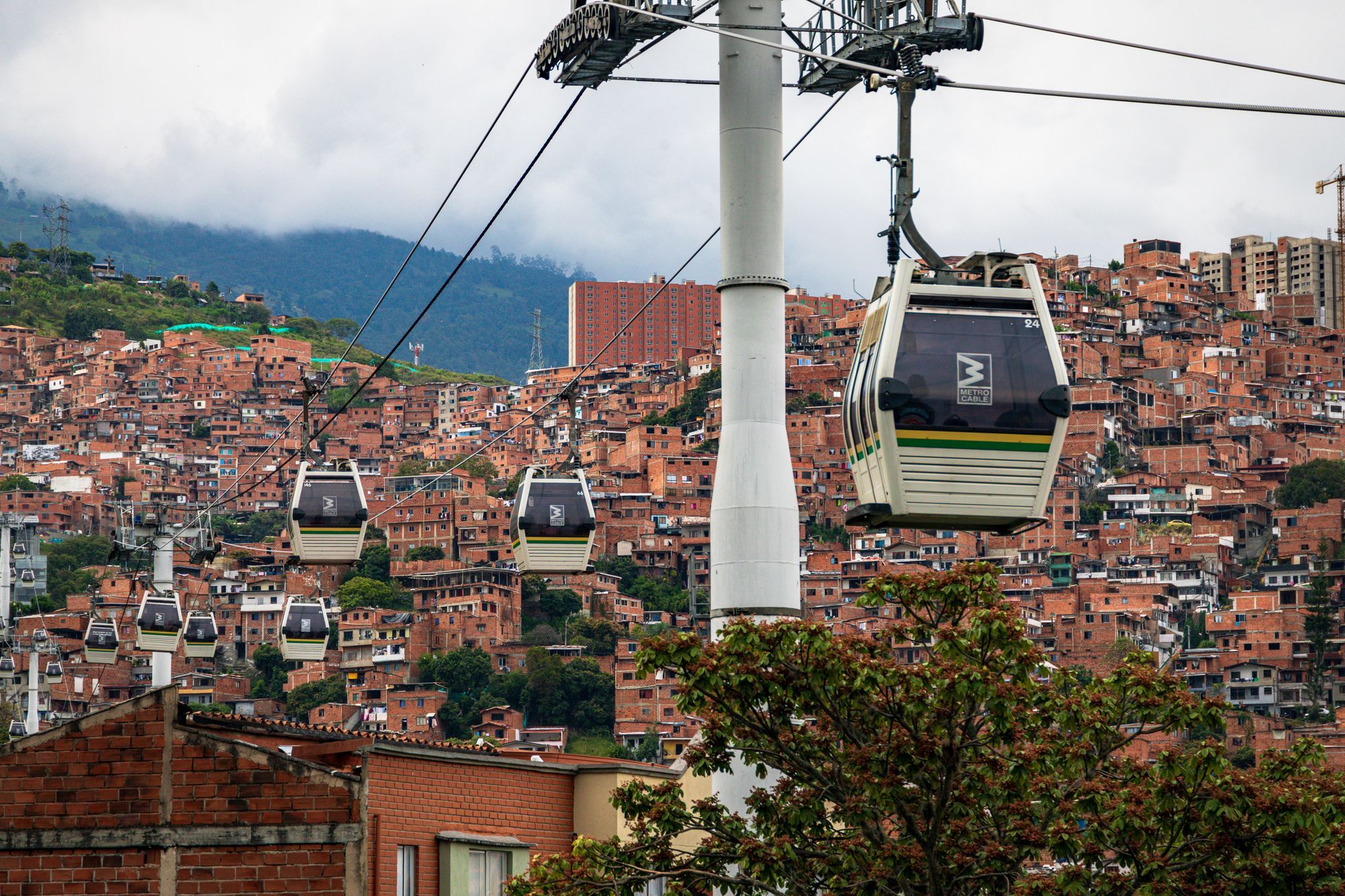 Cabinas del Metrocable sobre los barrios de ladrillo en las laderas de Medellín.