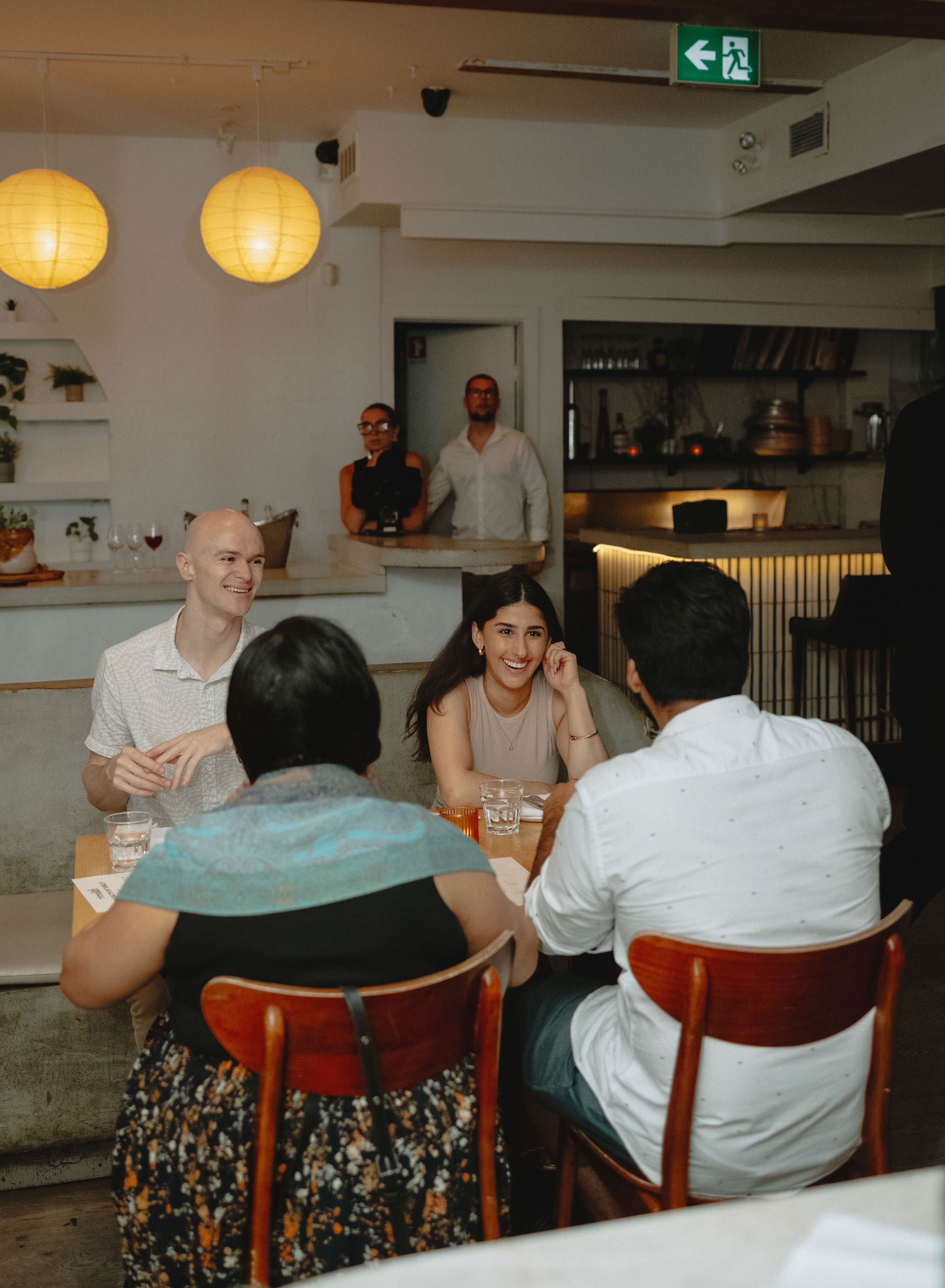 A small group sitting down together at the start of a Timeleft dinner