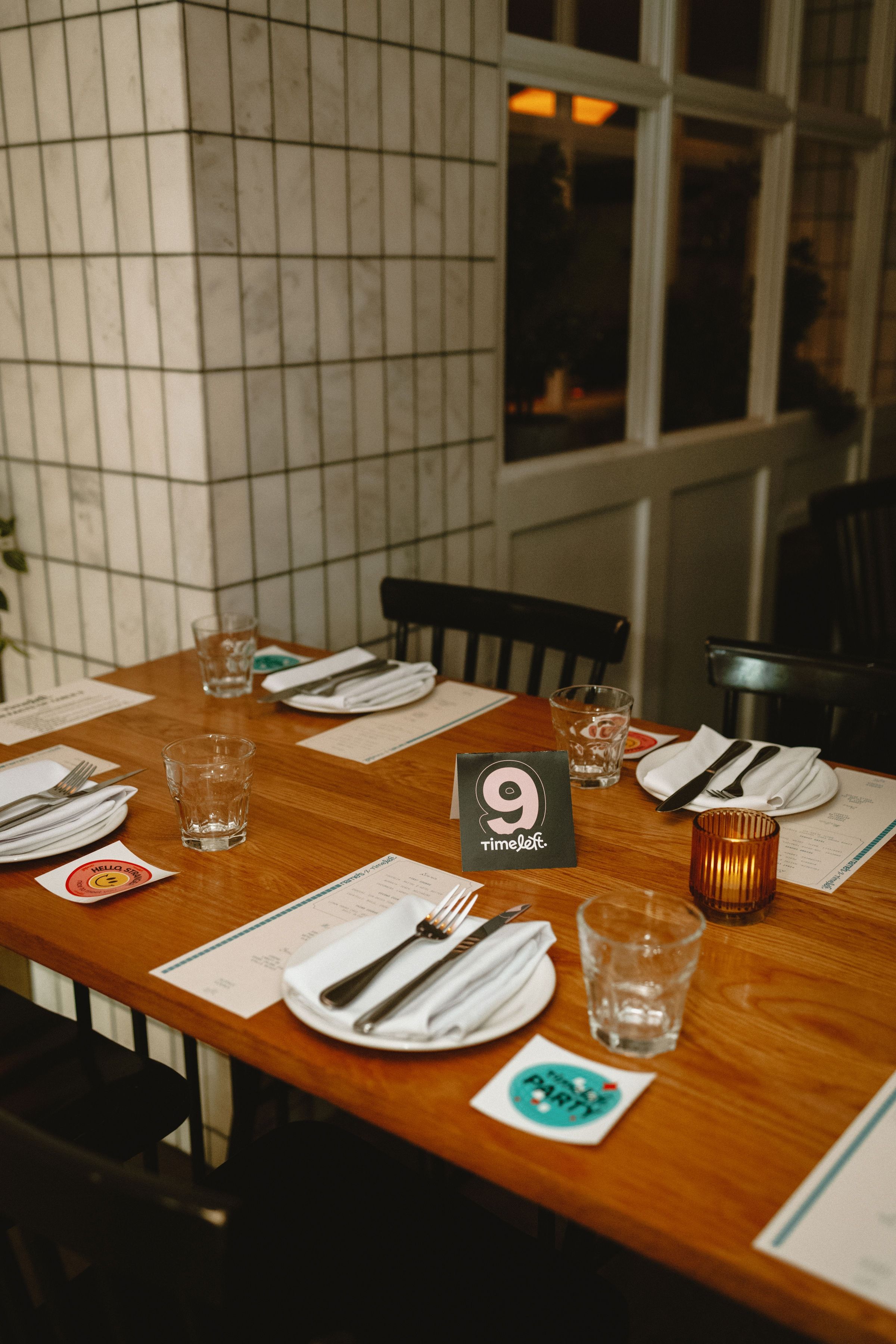 A table laid for a Timeleft dinner, with a number card, napkins and glasses of water