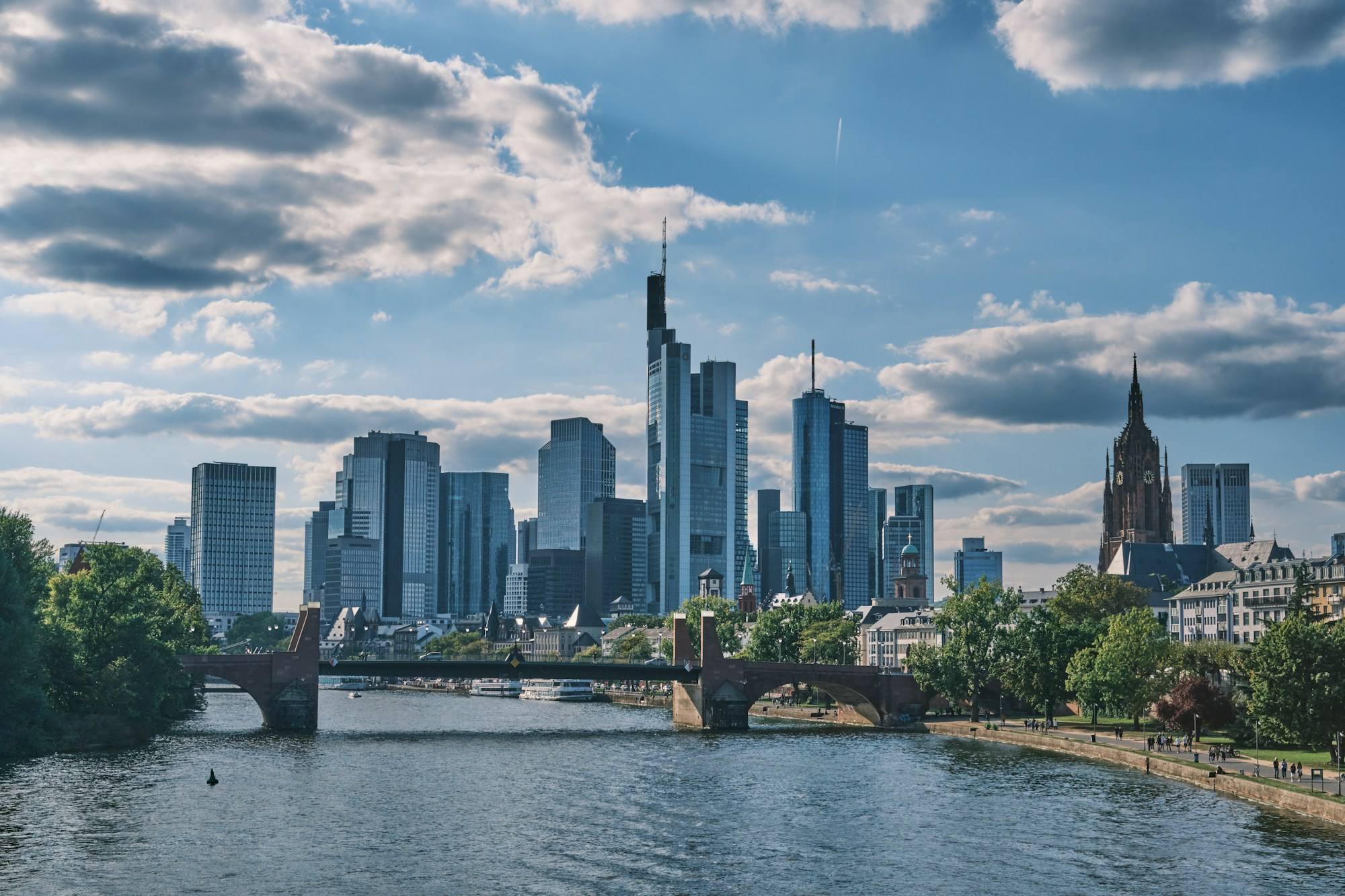 The Frankfurt skyline above the river Main, with a stone bridge in front