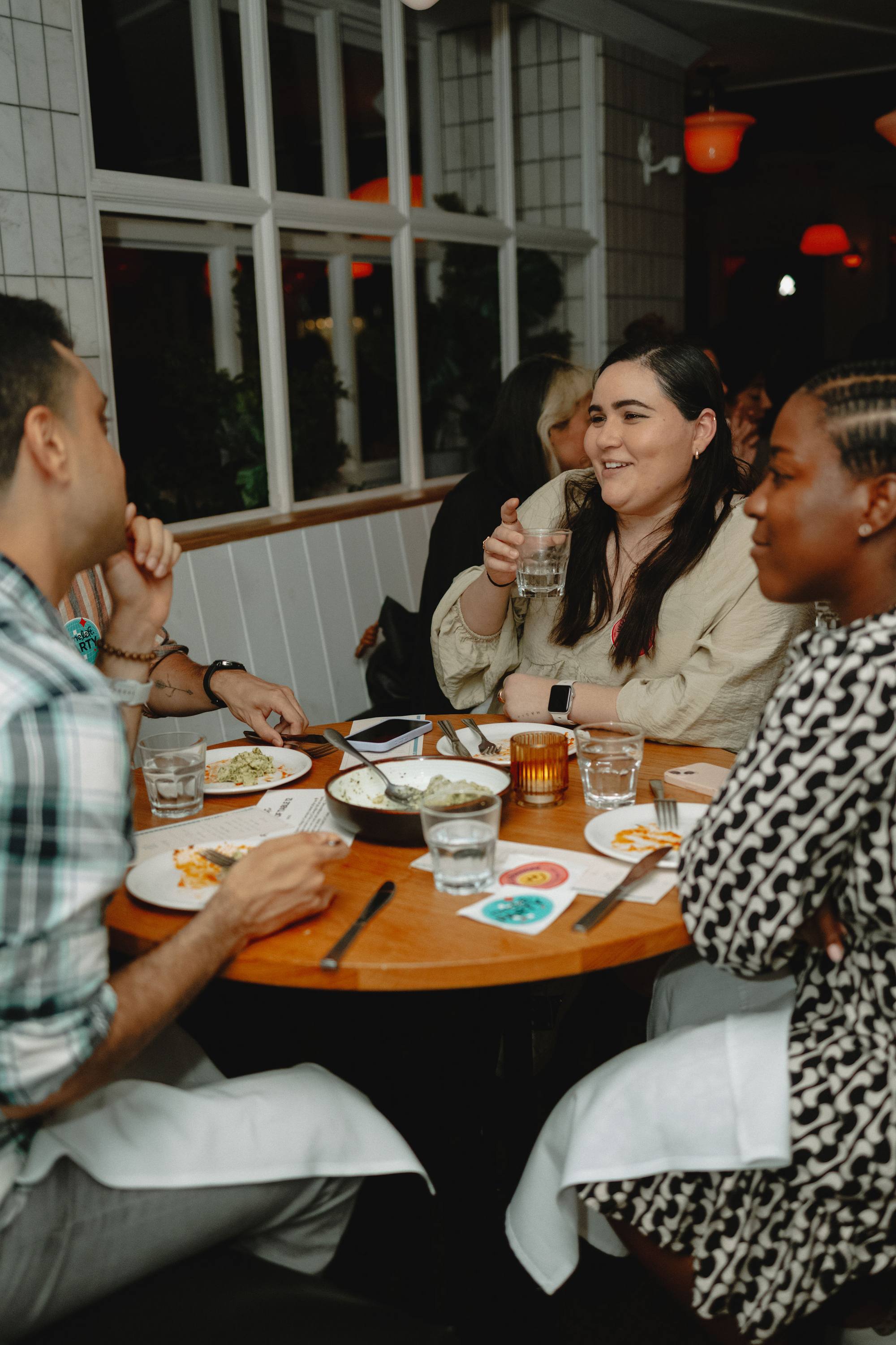 Four people talking and laughing around a round table at a Timeleft dinner