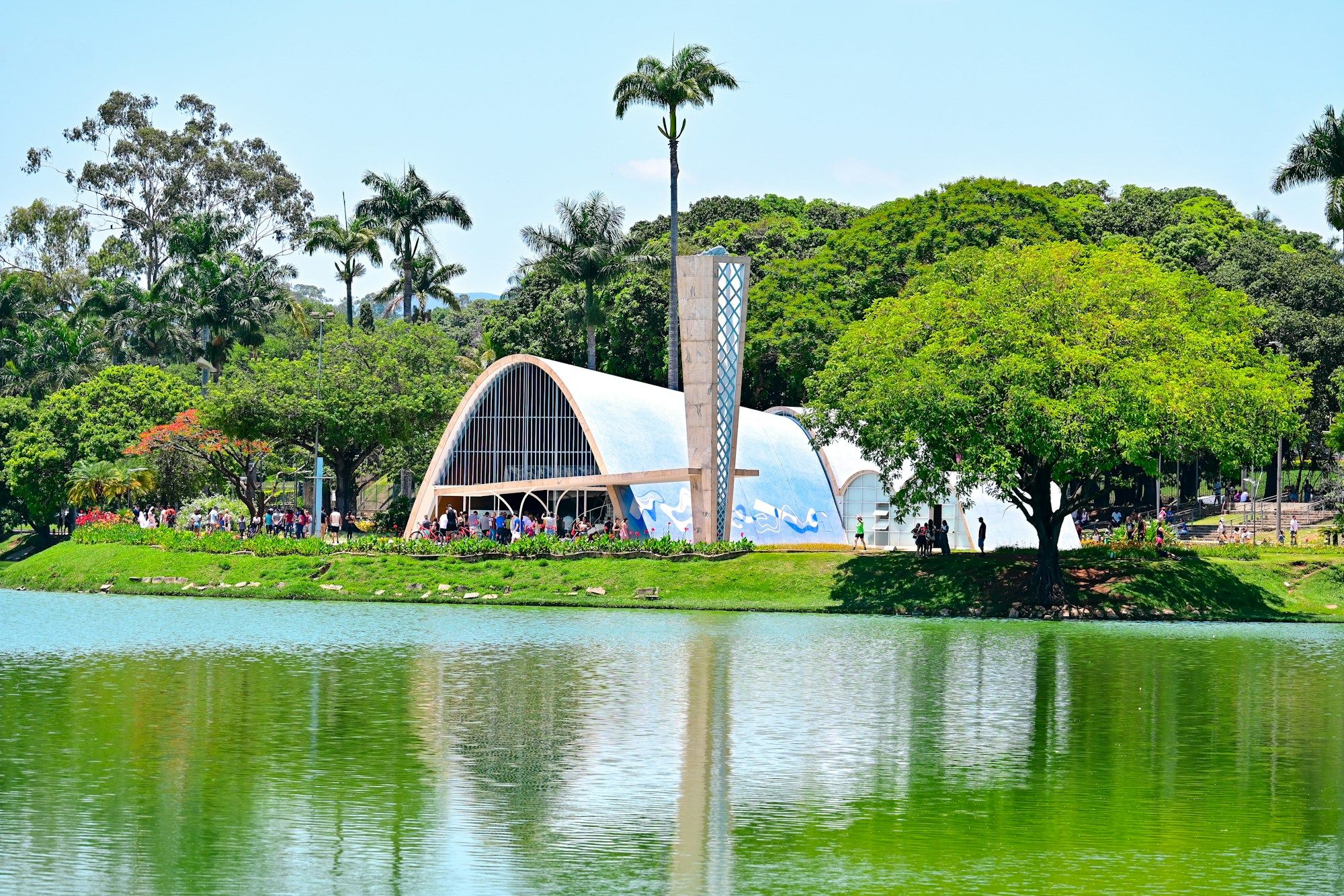 The Church of Saint Francis of Assisi at Pampulha, Belo Horizonte, seen across the lake among palm trees.
