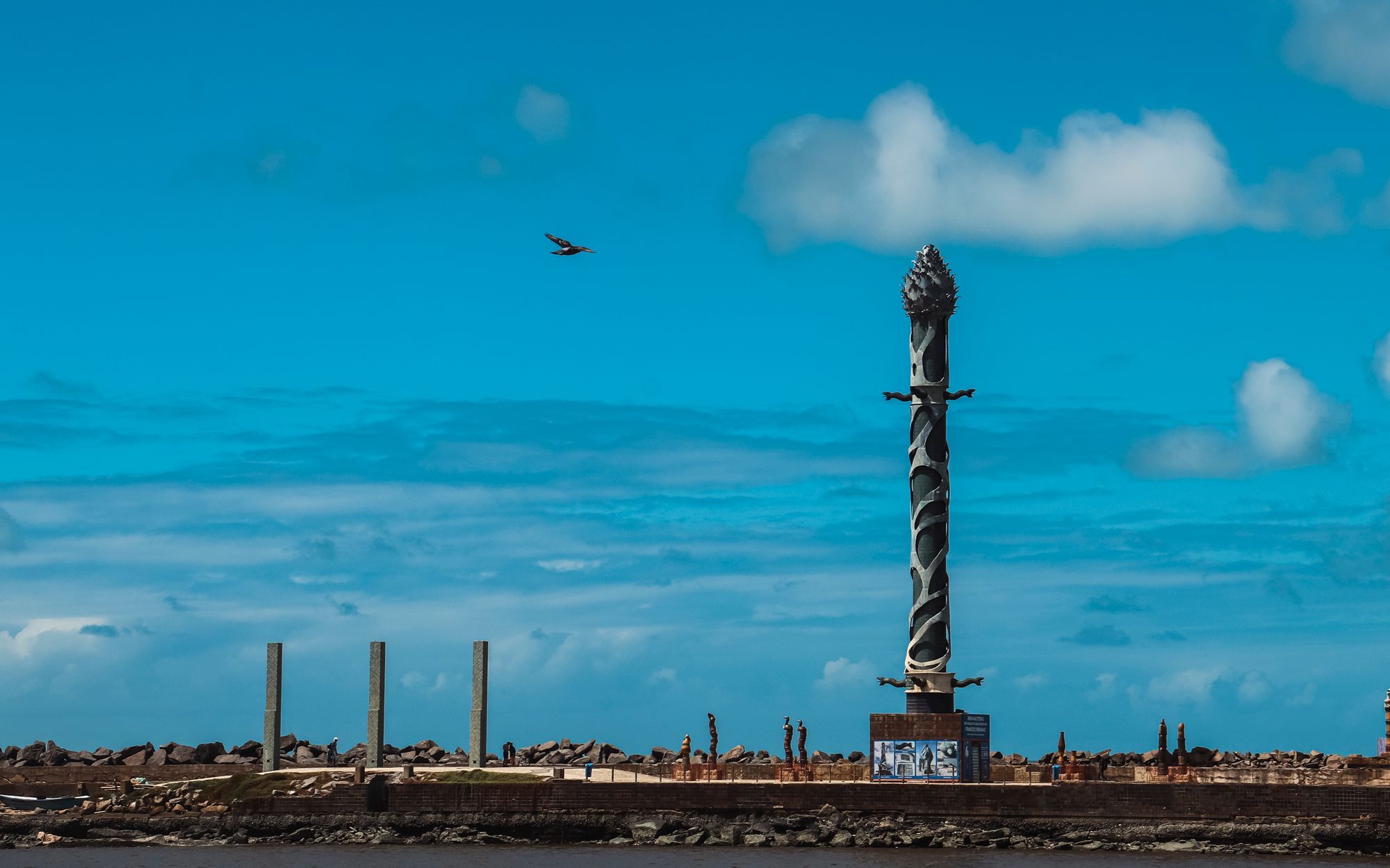 The Francisco Brennand sculpture column at the Parque das Esculturas in Recife, with the sea and sky behind it.