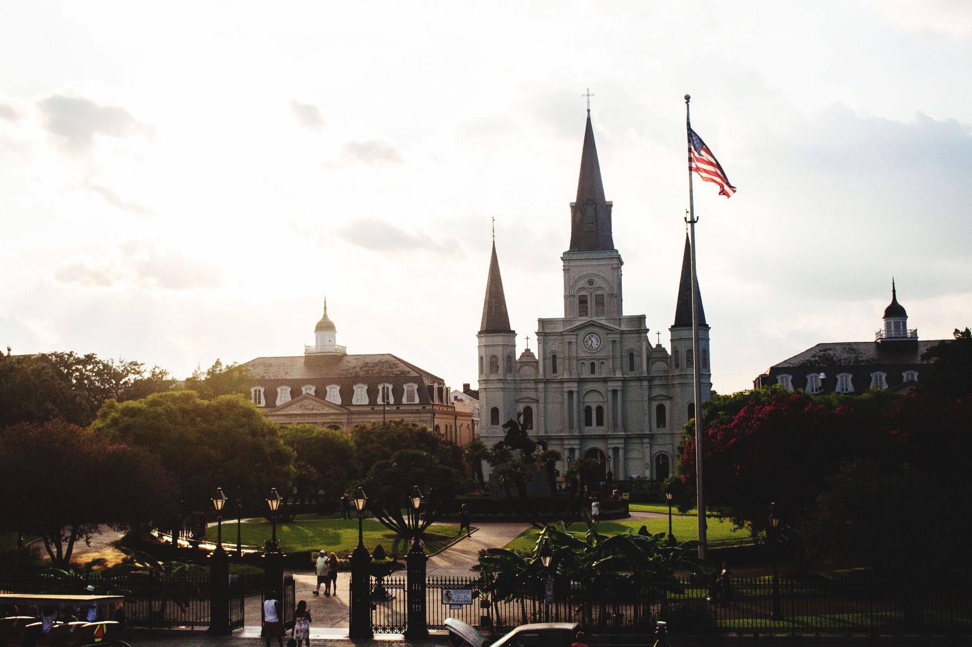 St. Louis Cathedral and Jackson Square in New Orleans at dusk, with the spires against a pale sky.