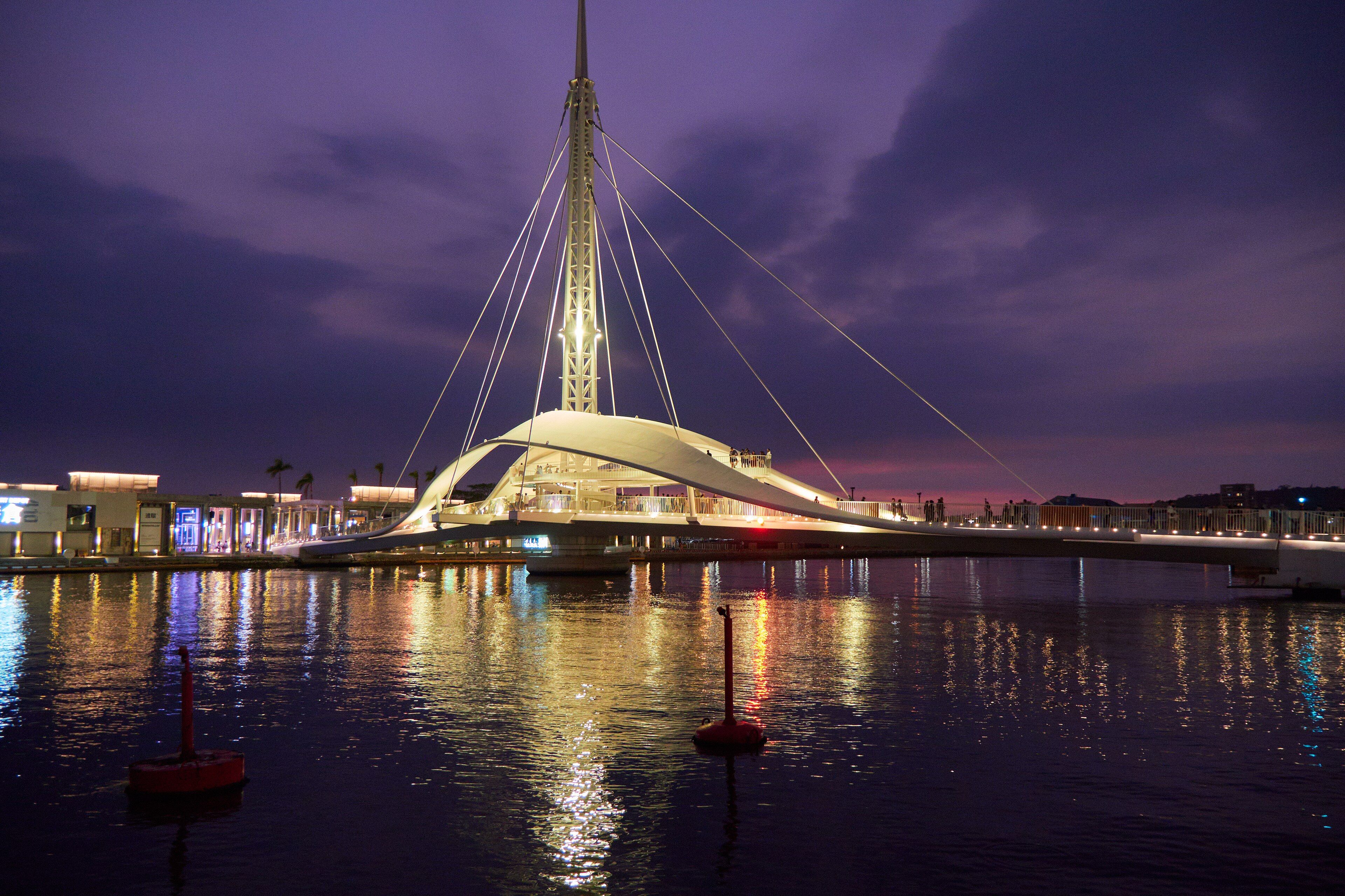 The sail-shaped pavilion and mast at the Pier-2 Art Center on Kaohsiung harbor at dusk.