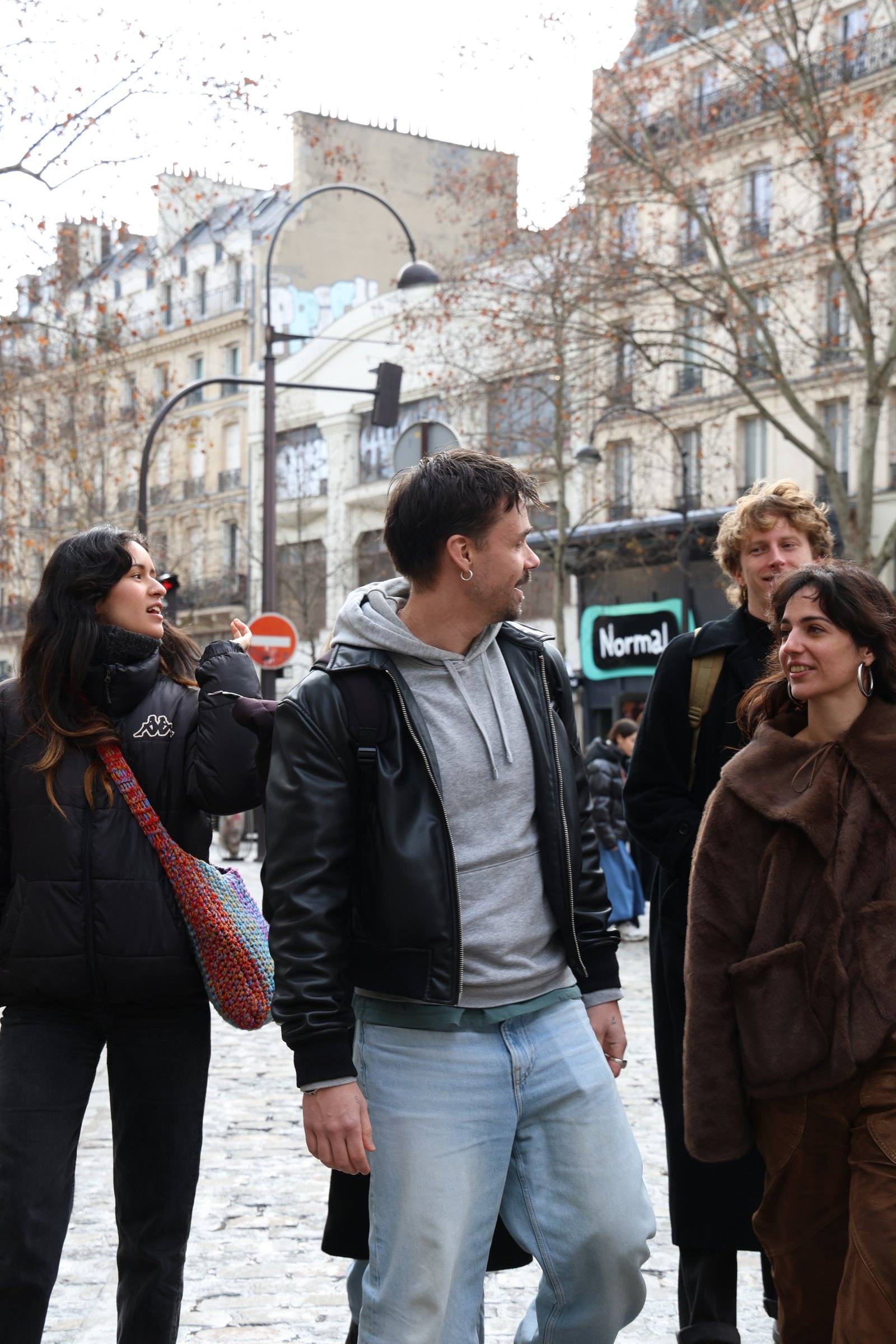 Four people talking as they walk along a tree-lined avenue on a Timeleft walk
