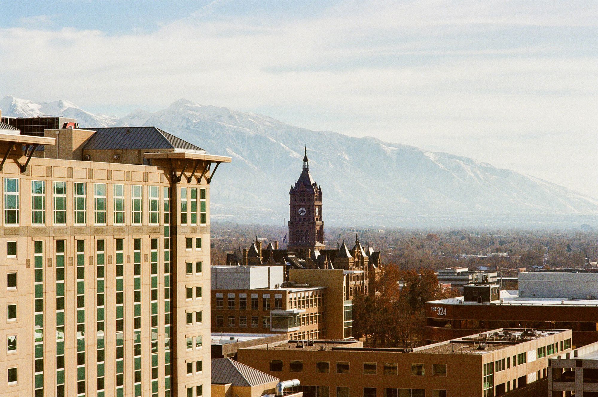 Downtown Salt Lake City with a clock tower and the snow-capped Wasatch Mountains behind.
