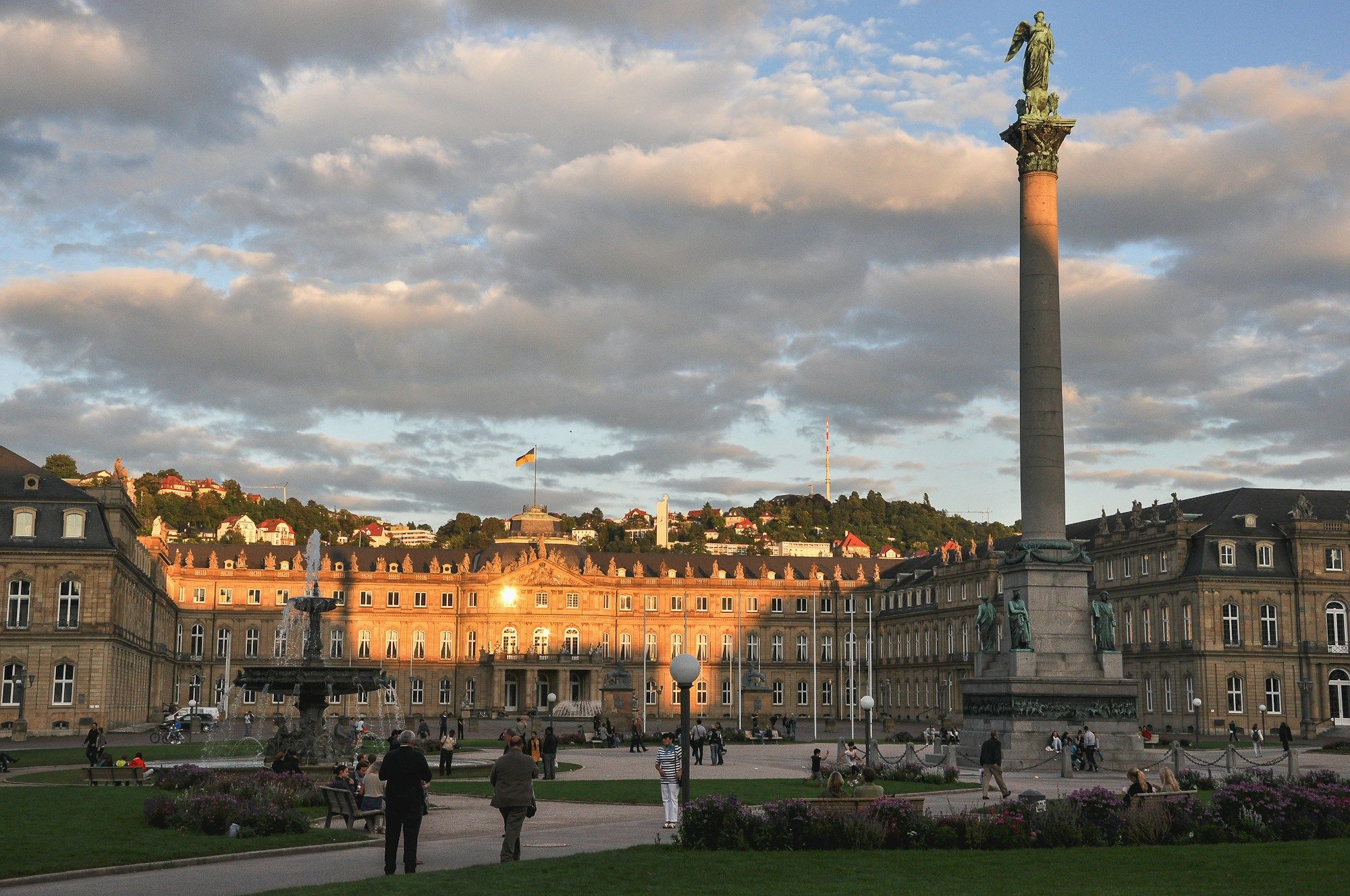 The Schlossplatz in Stuttgart at sunset, with the column and the New Palace and people in the square