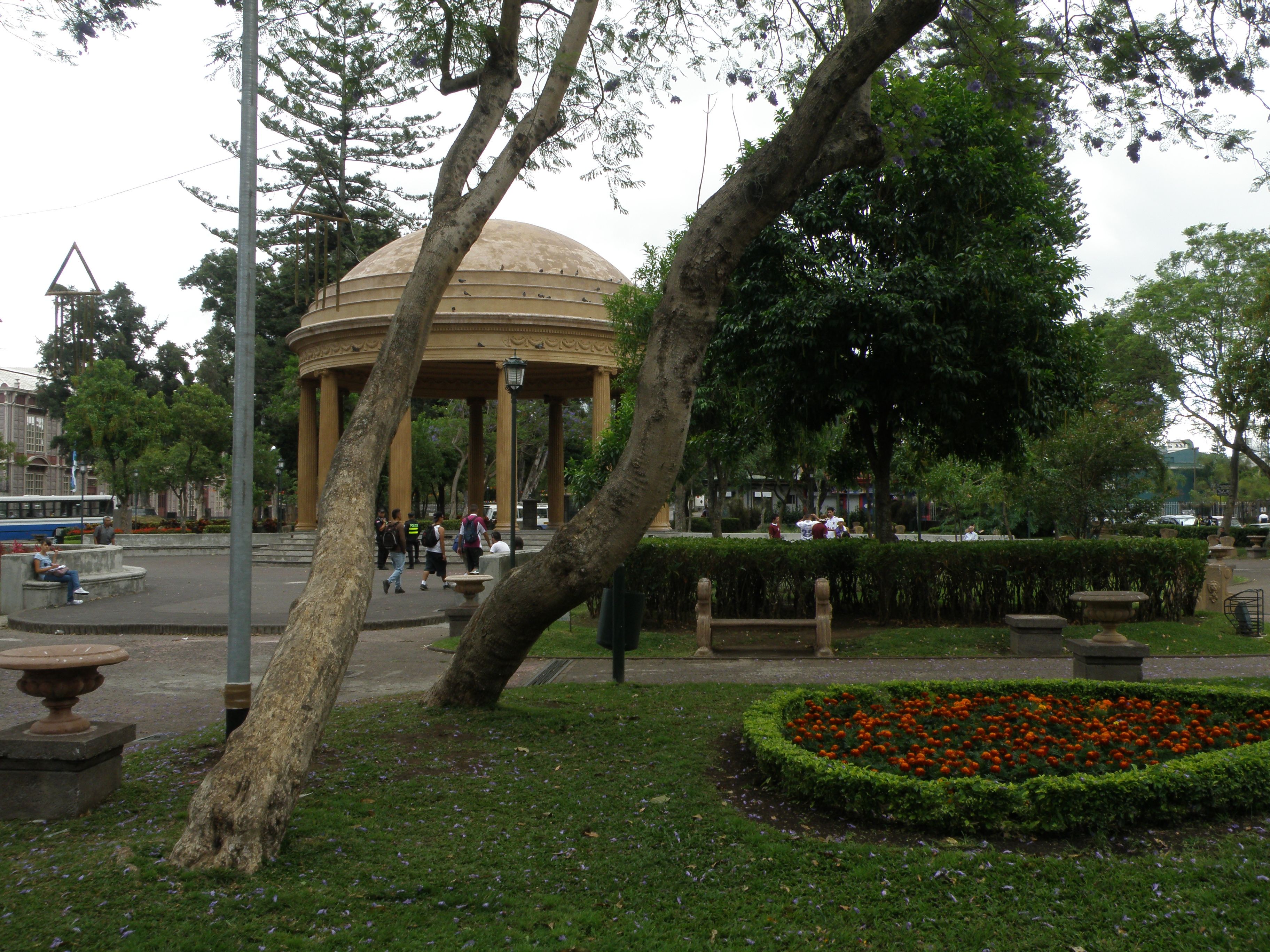 El Templo de la Música, con su cúpula, en el Parque Morazán de San José, con árboles y un jardín de flores.