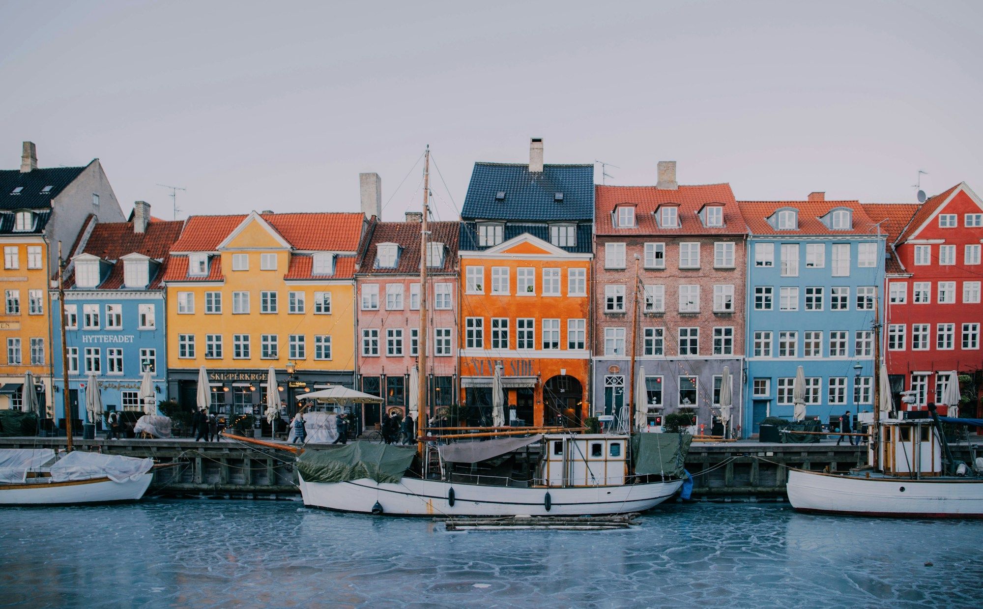 The coloured houses along the Nyhavn canal in Copenhagen, with boats in front