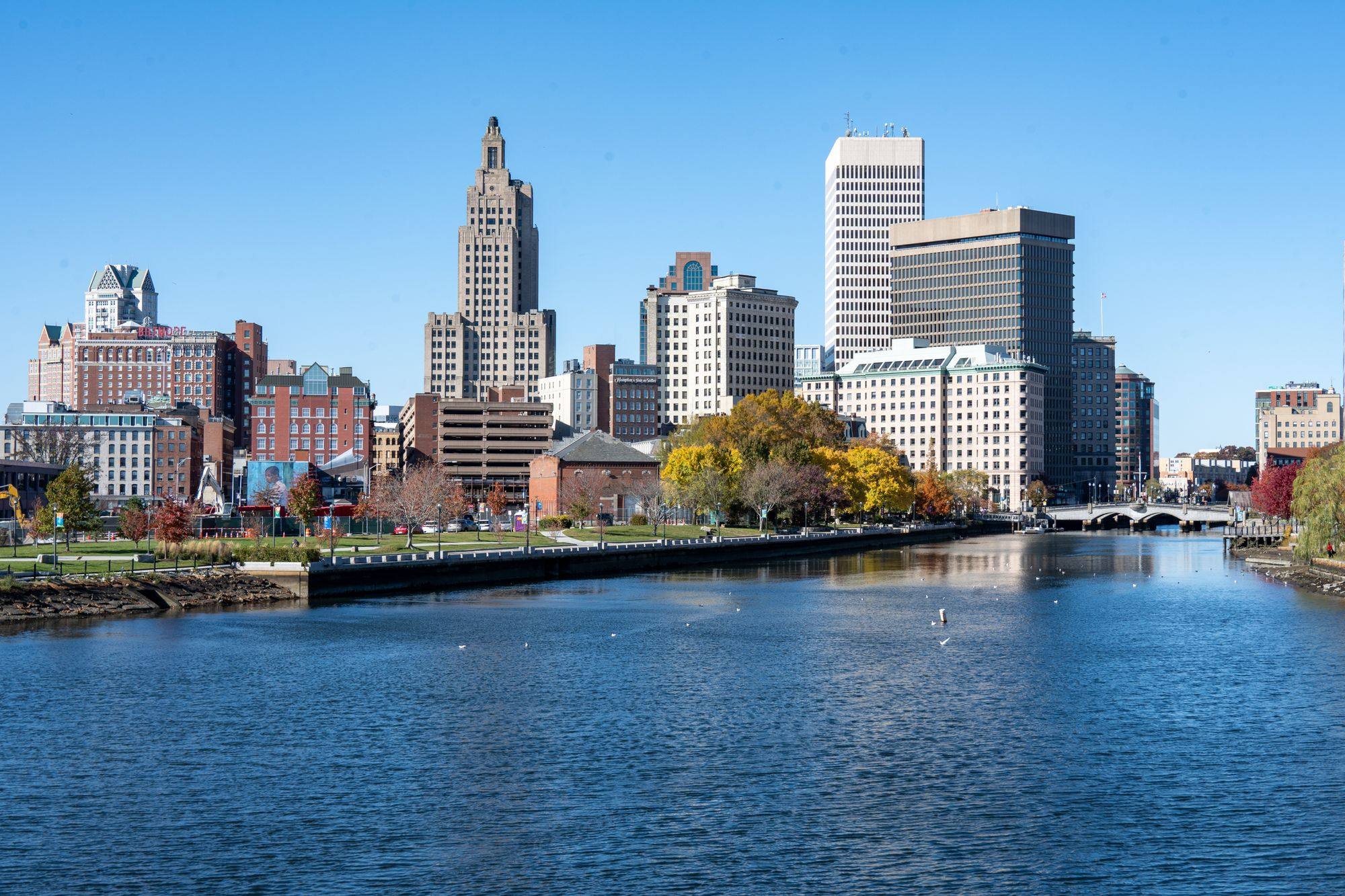The Providence skyline with the Industrial Trust tower beside the Providence River on a clear day.