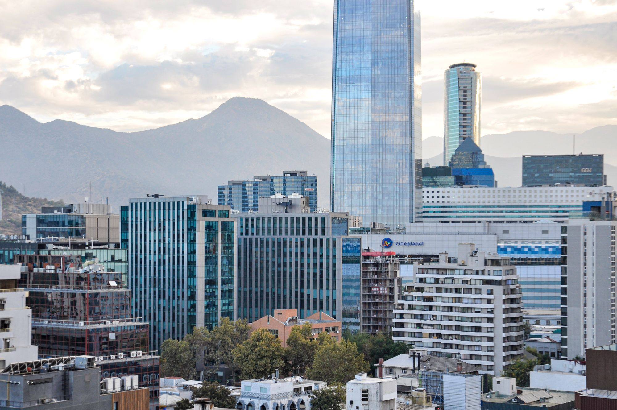 Gran Torre Santiago and other office towers in Santiago, with the Andes foothills behind them.