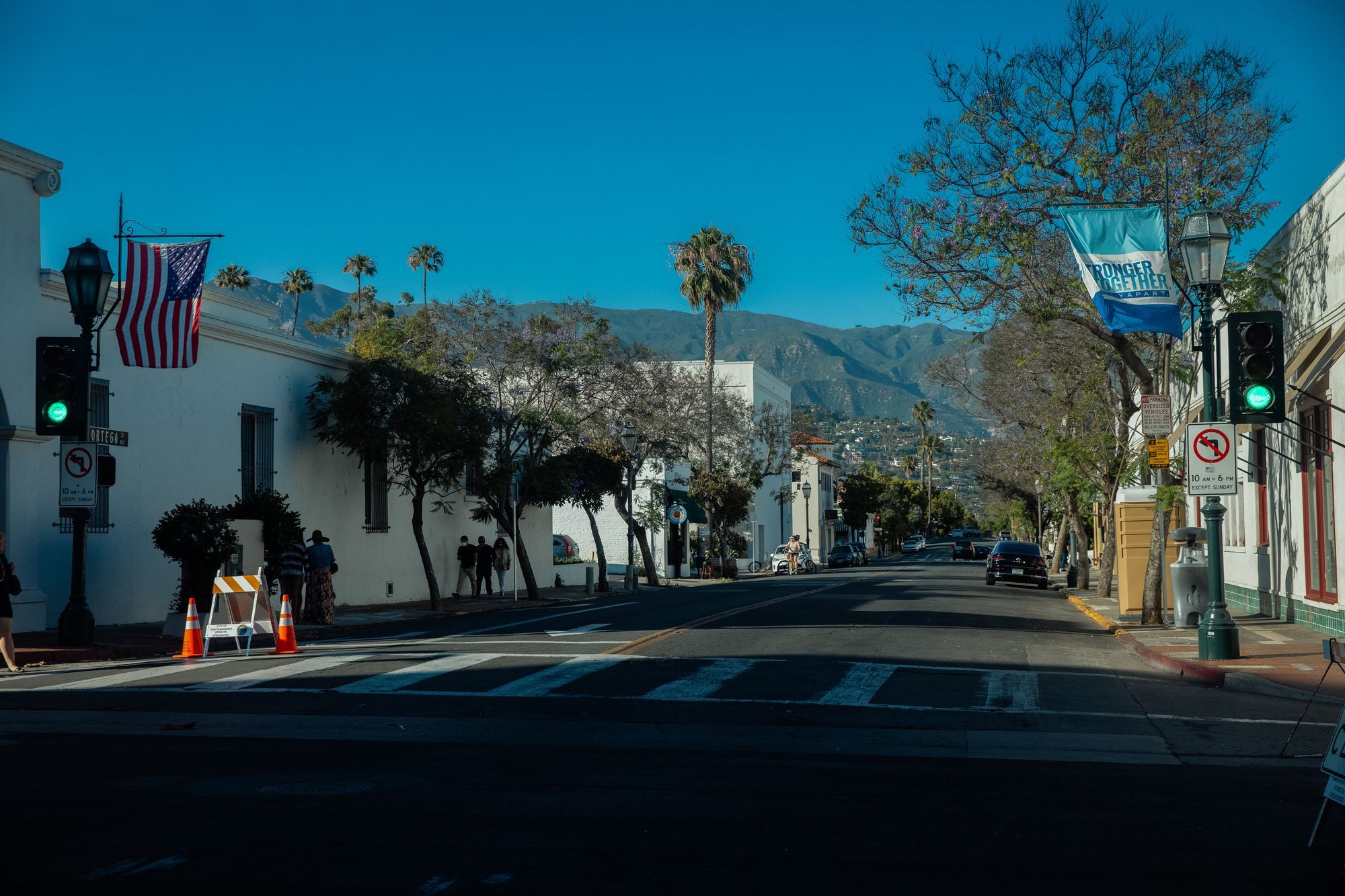 A quiet street in Santa Barbara with palm trees and the mountains behind.
