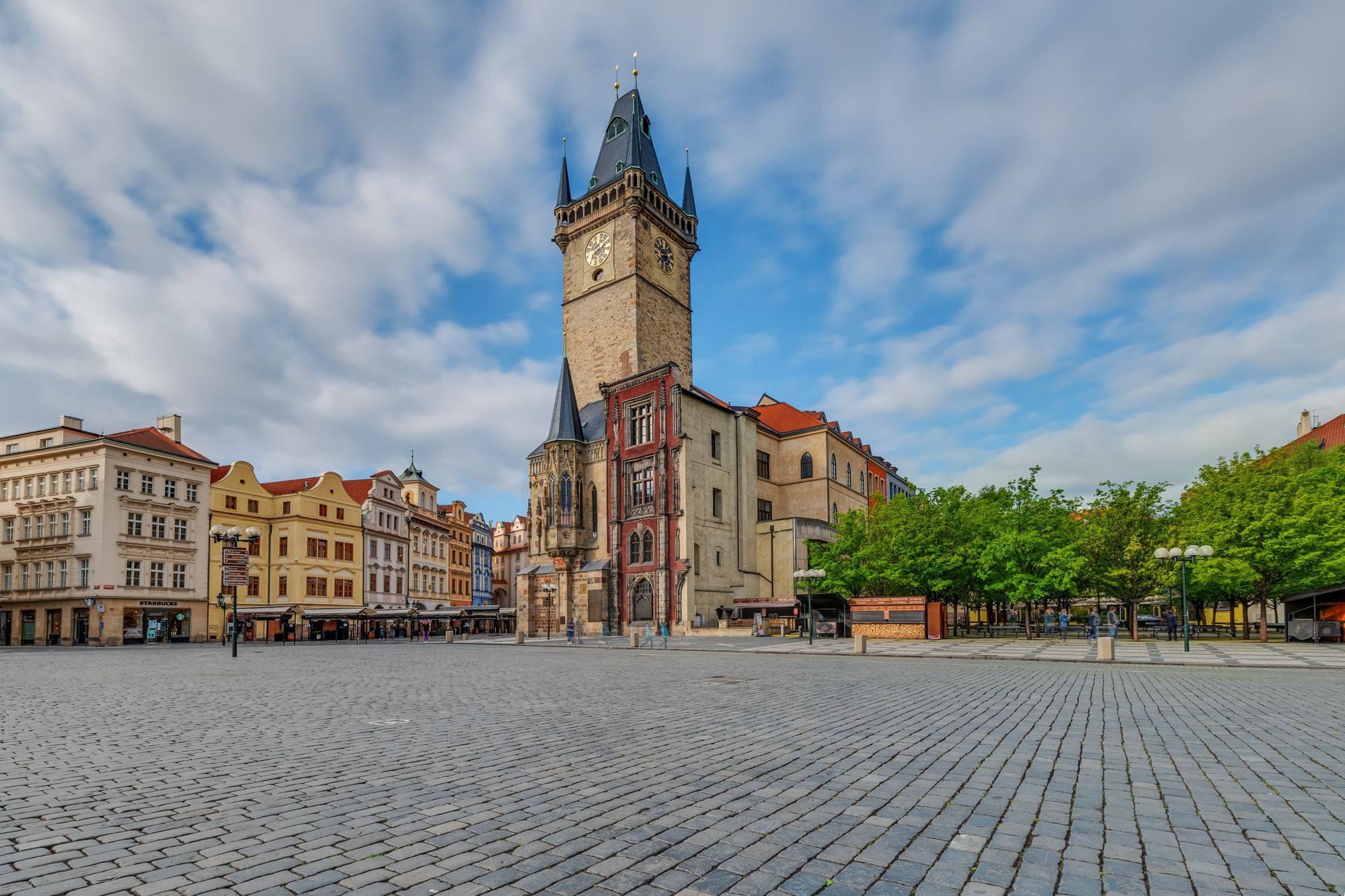 The Old Town Hall tower on Old Town Square in Prague, with the empty cobbled square in front.