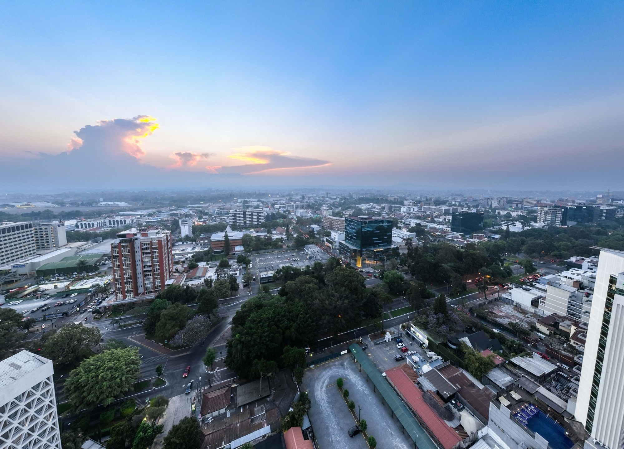 The buildings and streets of Guatemala City seen from above at sunset.