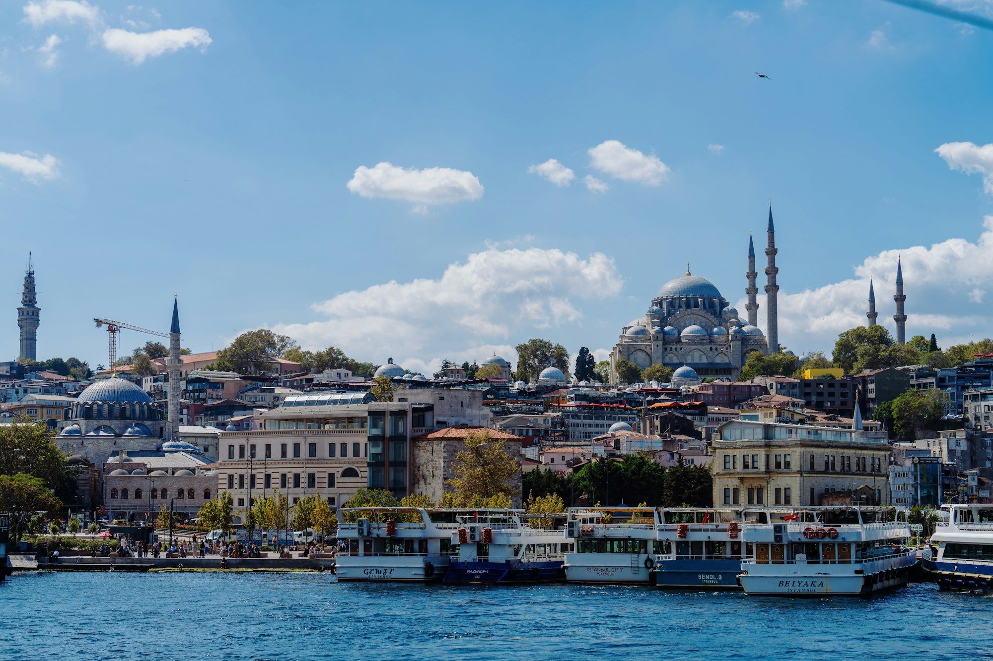 The Süleymaniye Mosque on the hill above the Eminönü waterfront in Istanbul, with passenger ferries moored below.