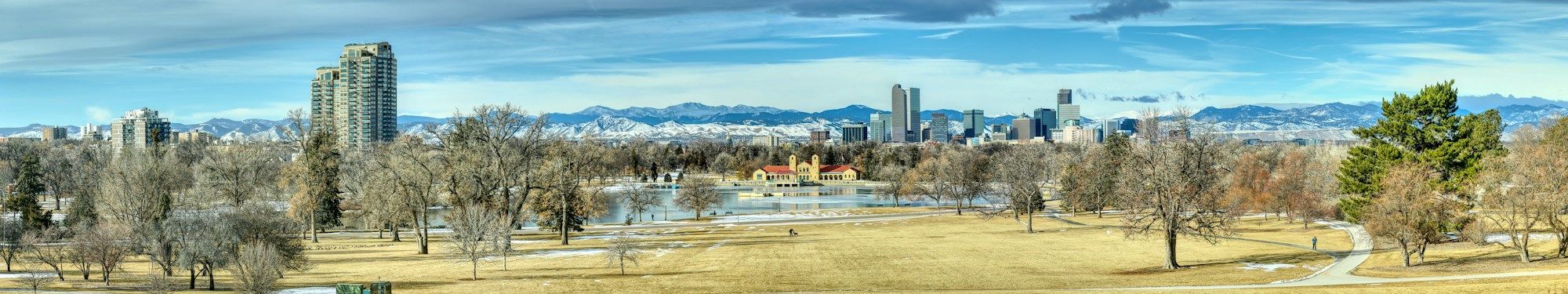 Ferril Lake and its pavilion in Denver's City Park, with the downtown towers and the snow-covered Rocky Mountains behind