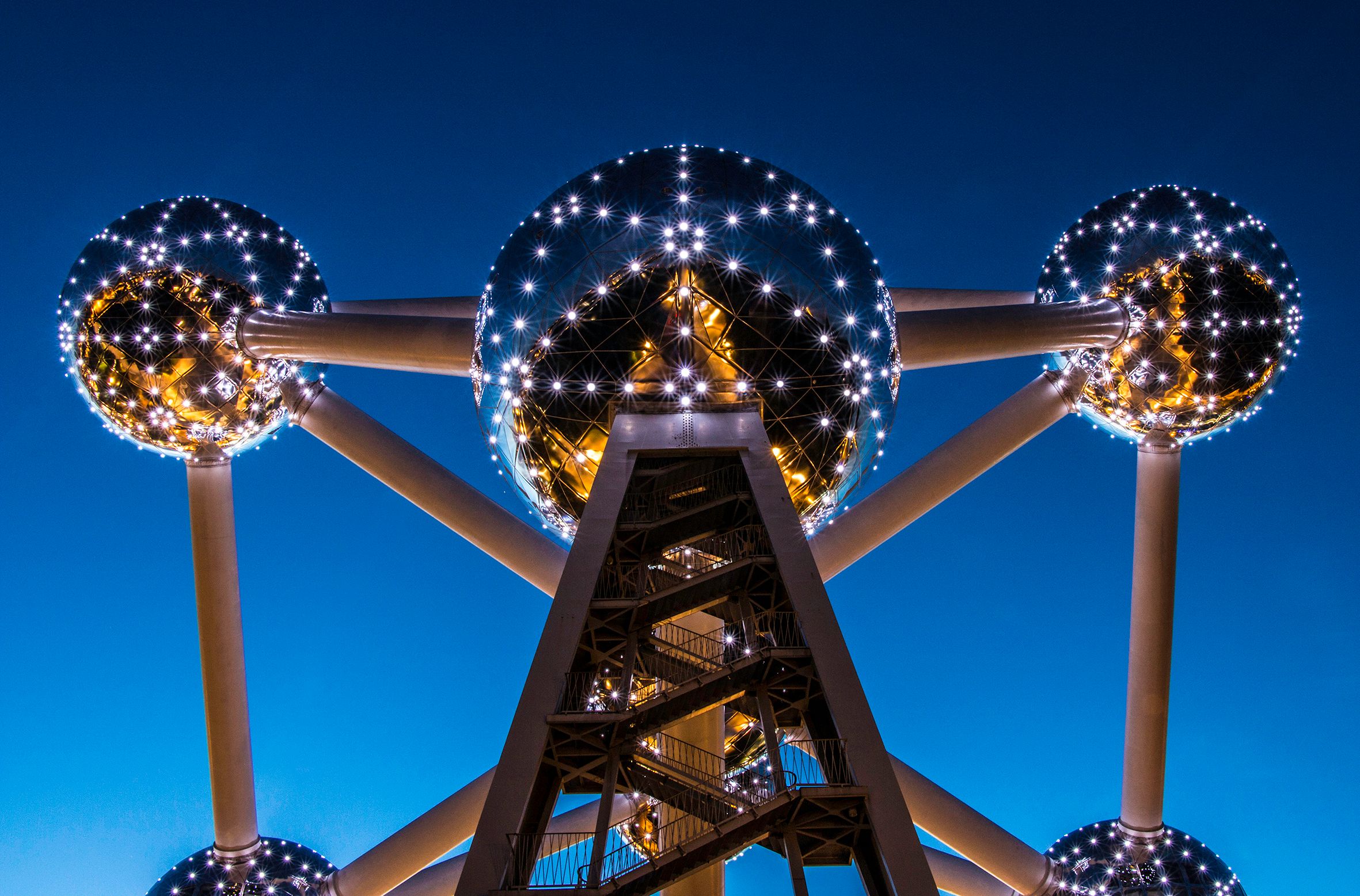 The Atomium in Brussels at dusk, with its spheres lit against a deep blue sky.