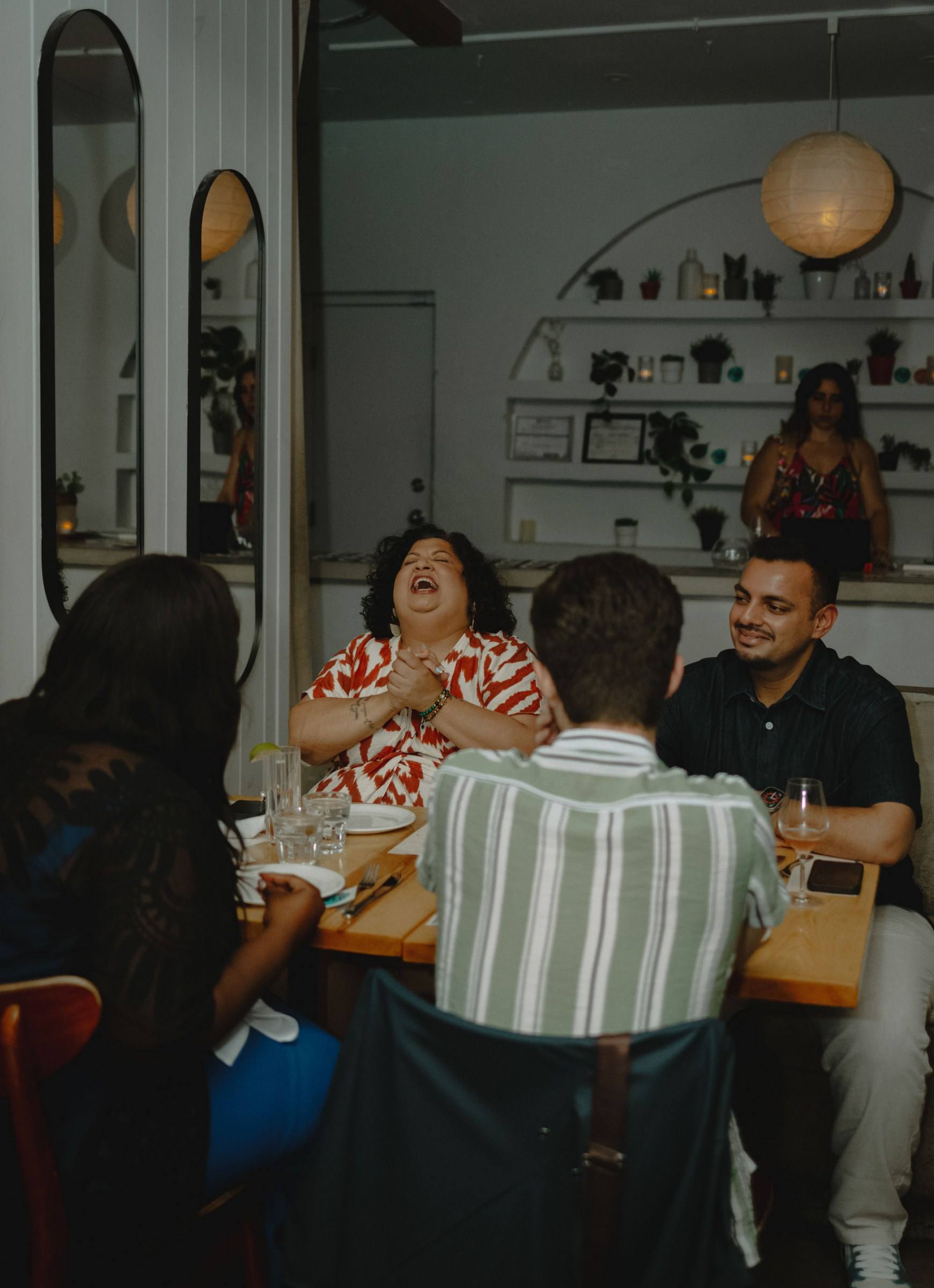 A woman laughing with three others at a Timeleft dinner