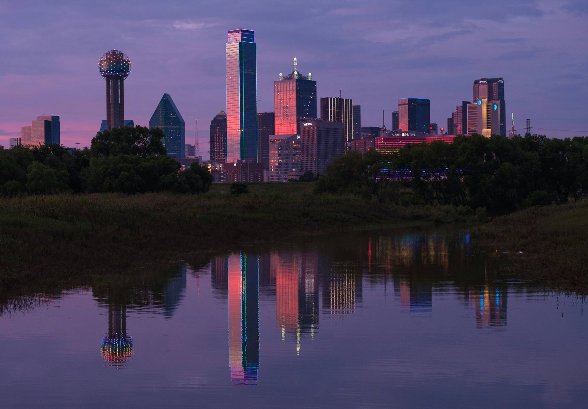 Downtown Dallas at sunset, reflected in still water across the Trinity River