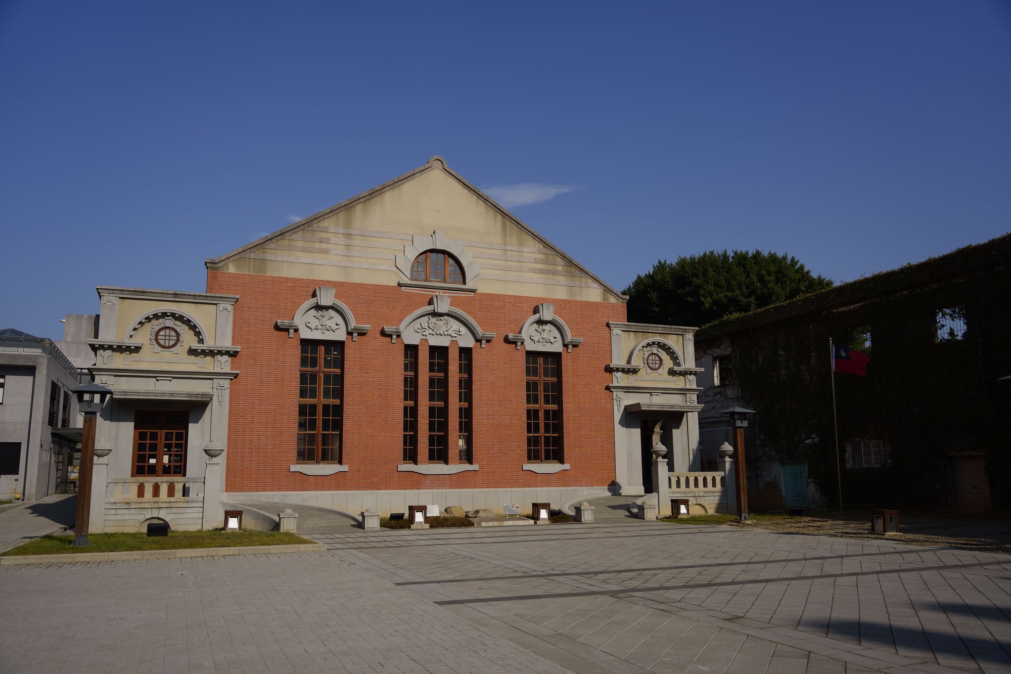 A brick and stucco heritage building with arched windows in Hsinchu City under a clear blue sky.