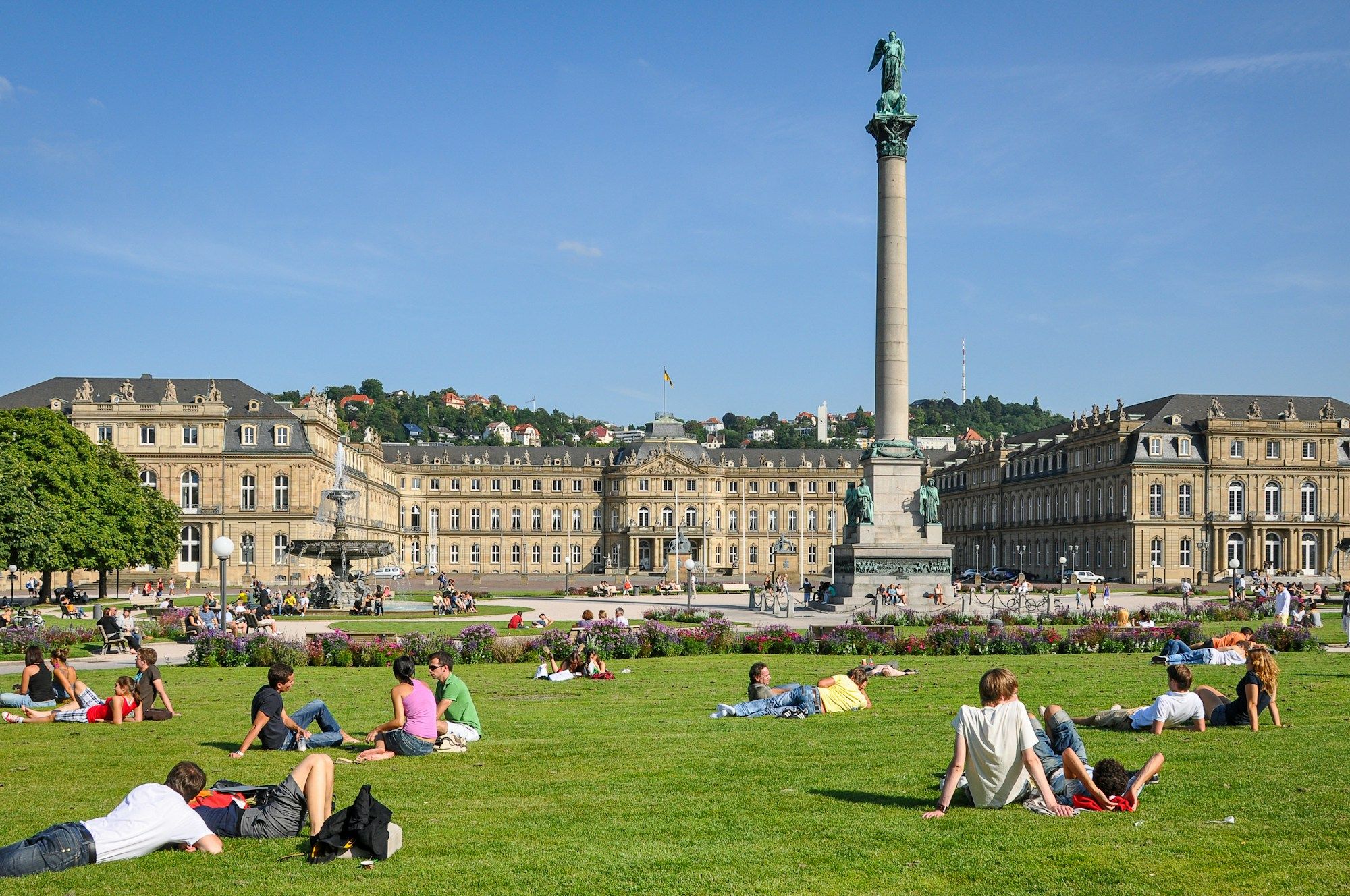 The Jubilee Column and the New Palace on Stuttgart's Schlossplatz, with people on the lawn