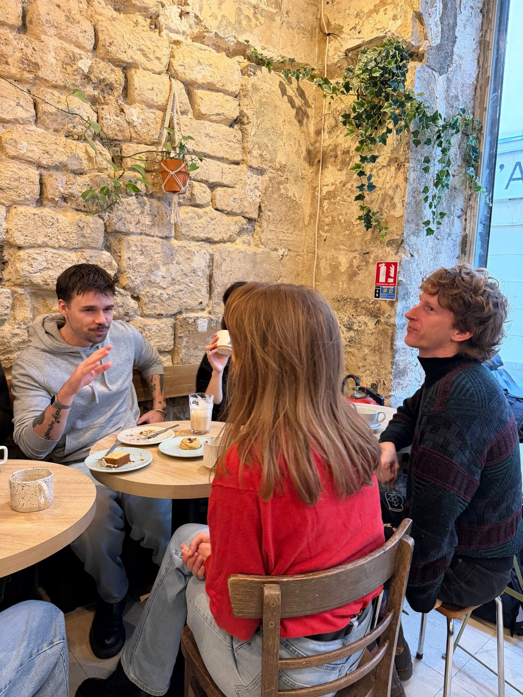 People talking across two café tables at a Timeleft coffee