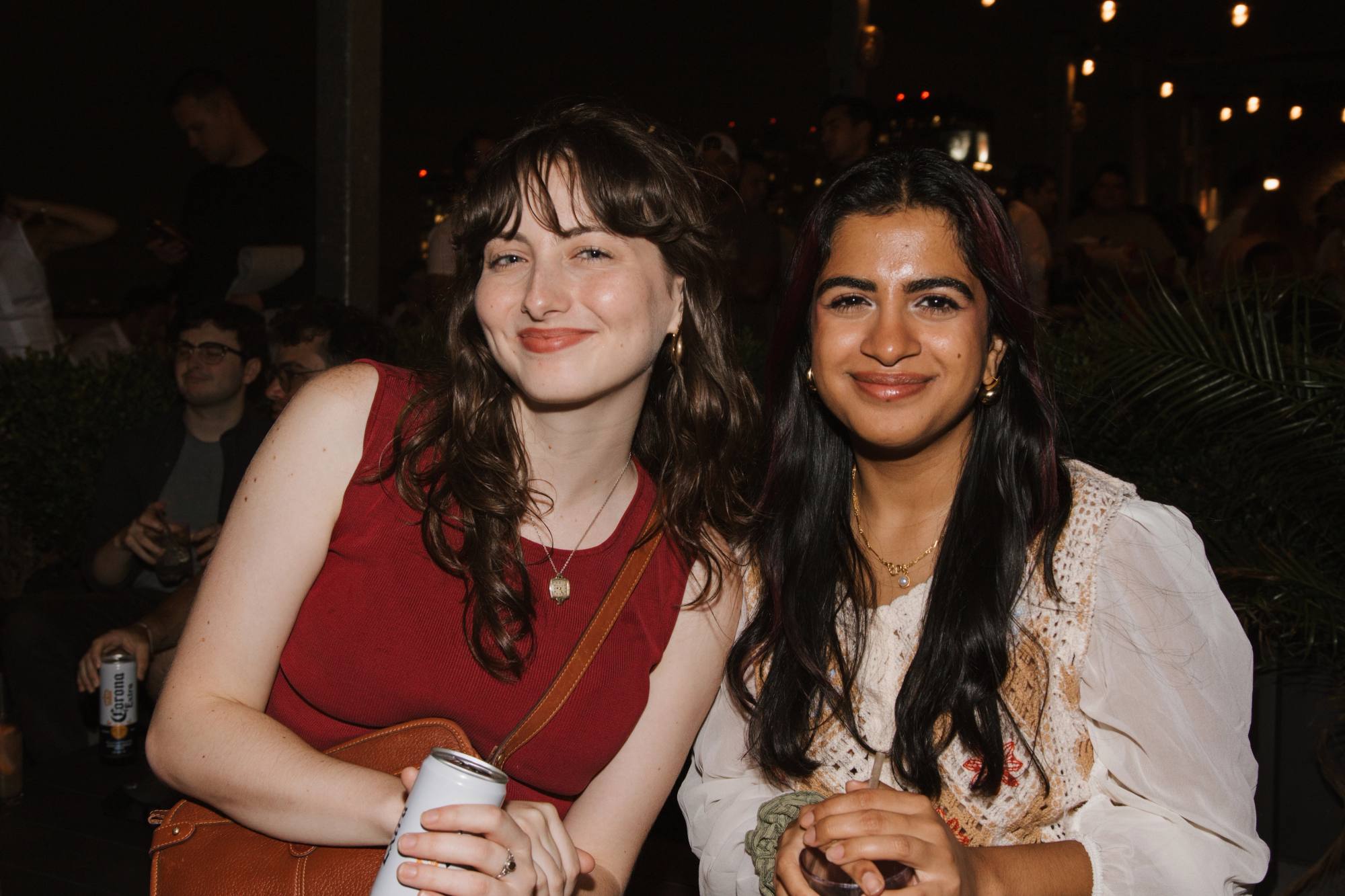 Two women smiling side by side at an evening event