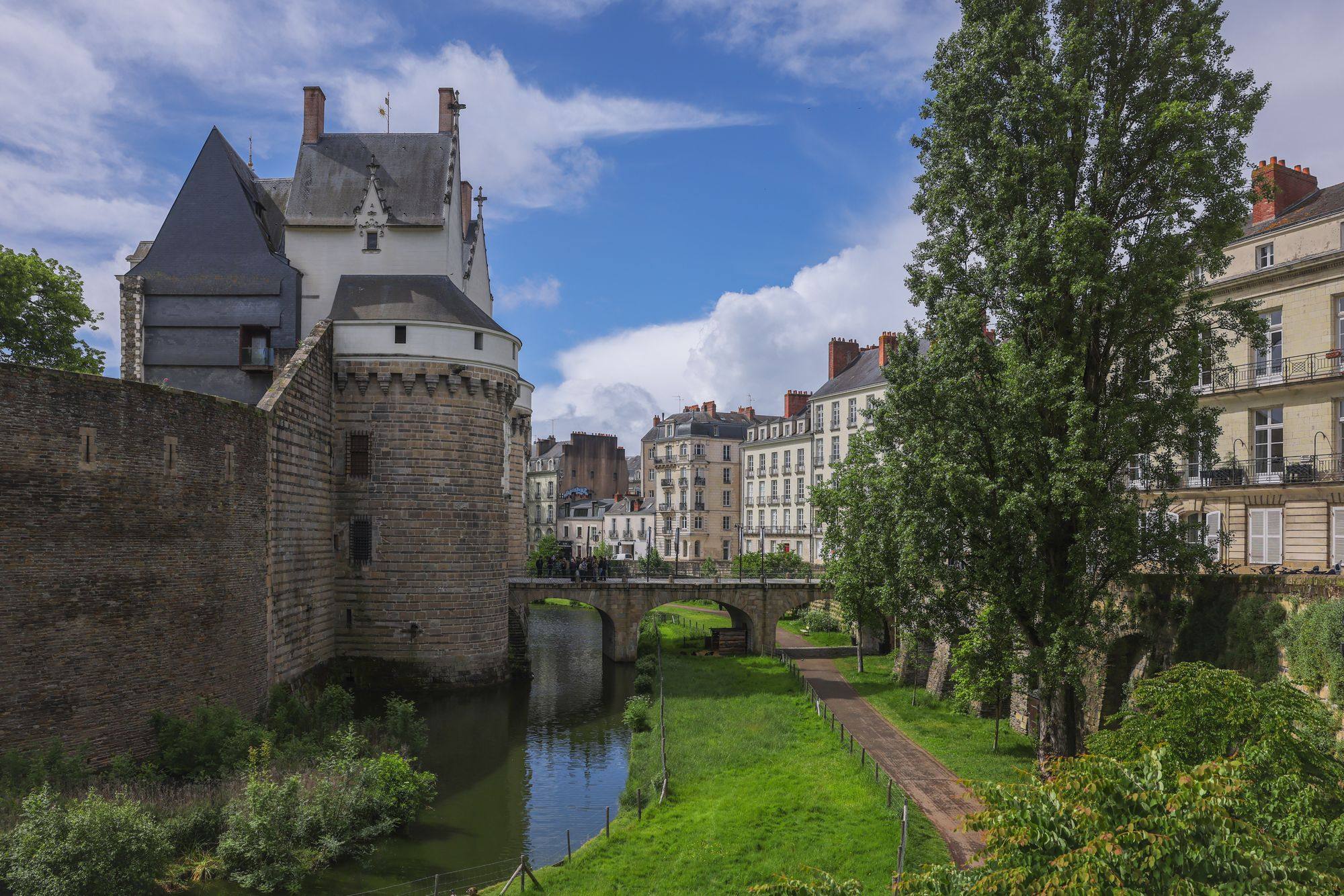 The Château des Ducs de Bretagne and its moat in Nantes, with townhouses behind.