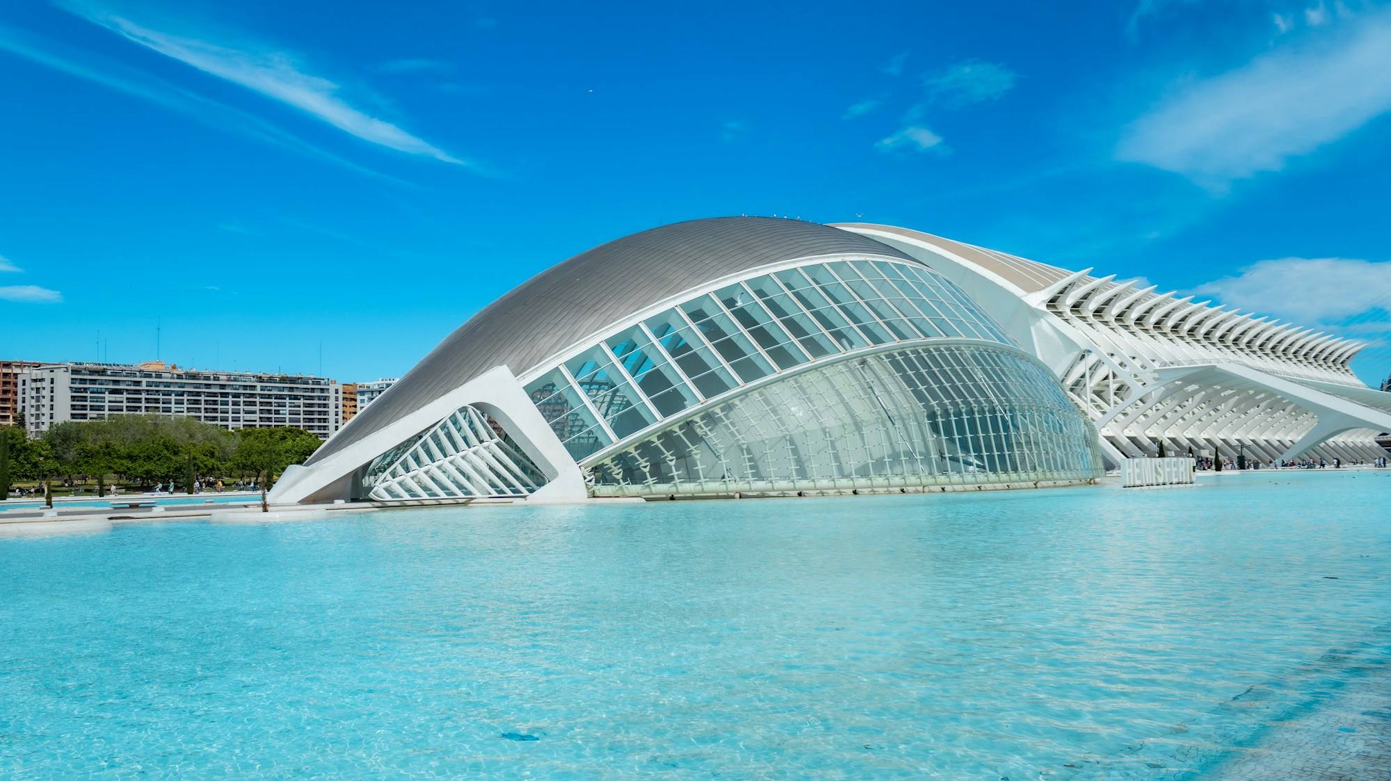 L'Hemisfèric at the City of Arts and Sciences in Valencia, a long white building above a pale blue pool.