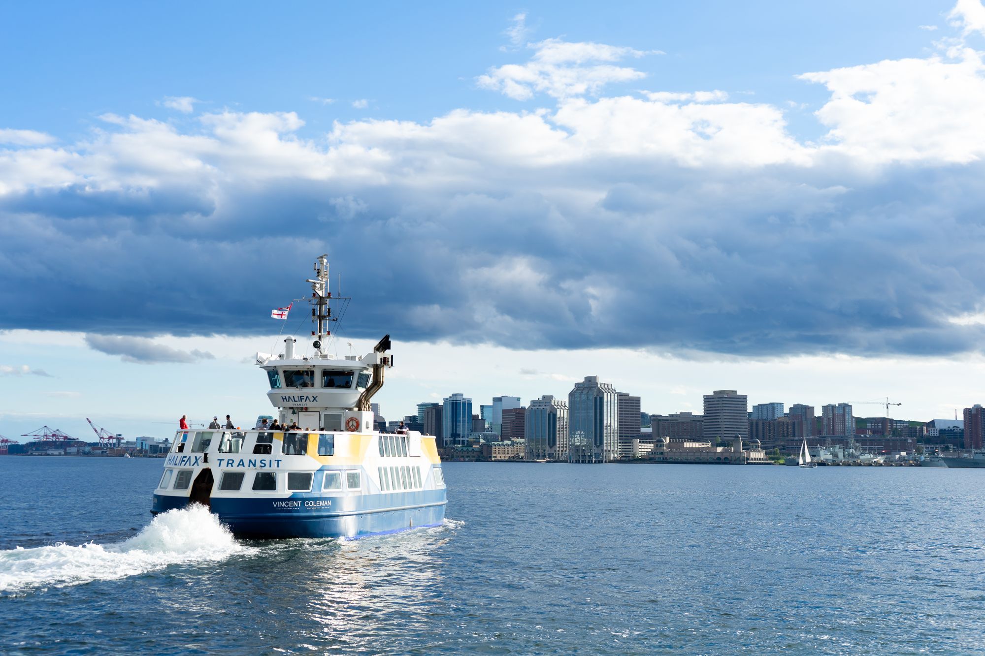 A Halifax Transit ferry crossing the harbor with the downtown skyline on the far shore.