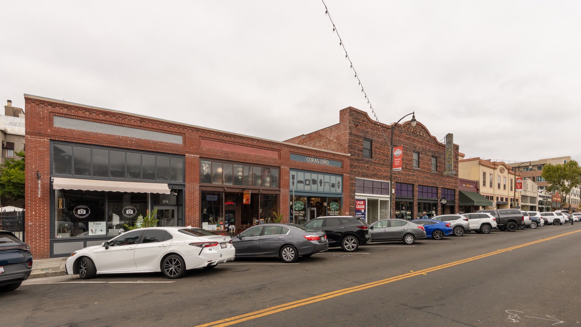 Brick storefronts and parked cars along Fourth Street in Santa Rosa’s Railroad Square Historic District.