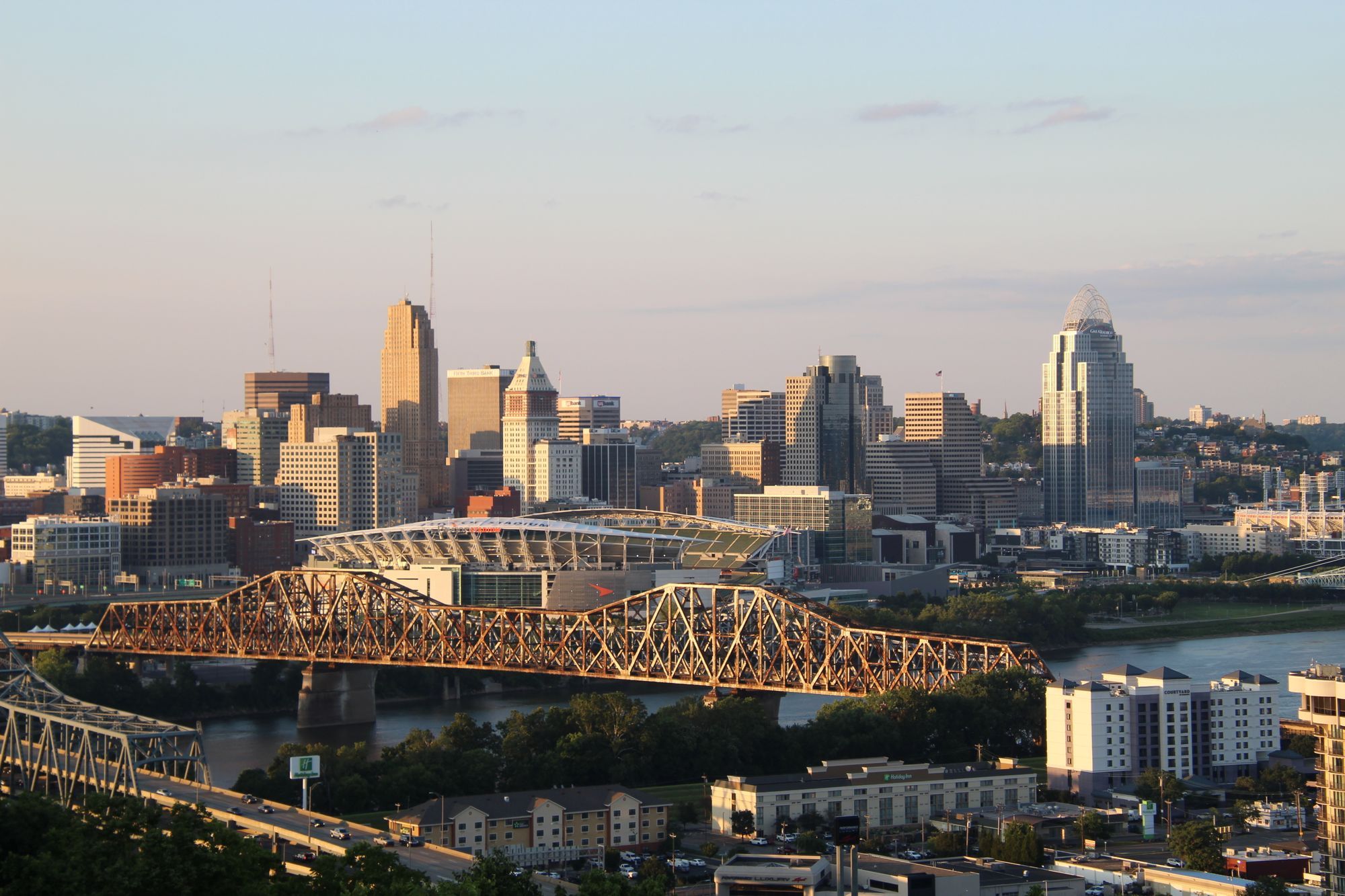 The Cincinnati skyline and the bridges over the Ohio River at dusk.