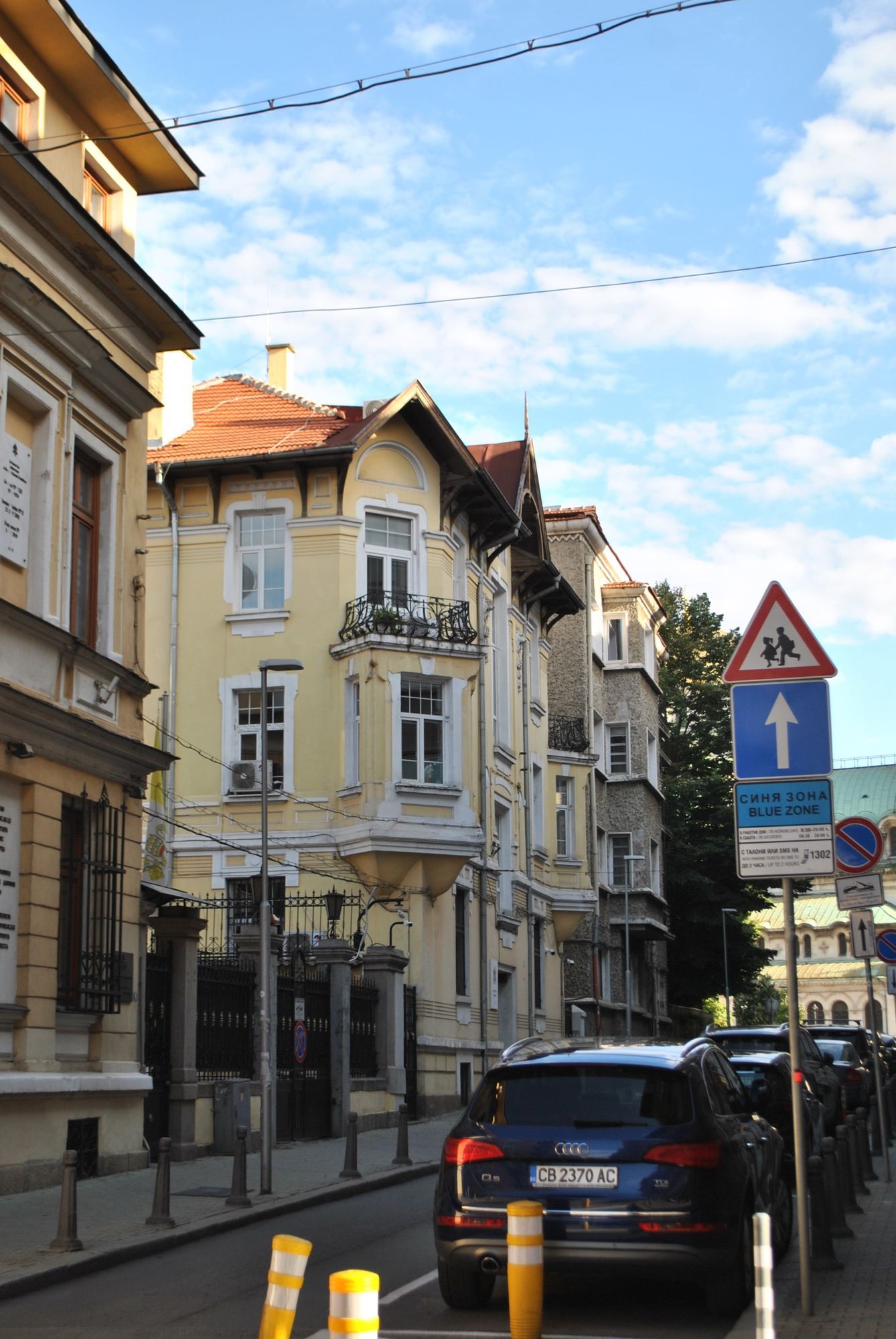 A street of yellow and orange townhouses in central Sofia on a sunny day.