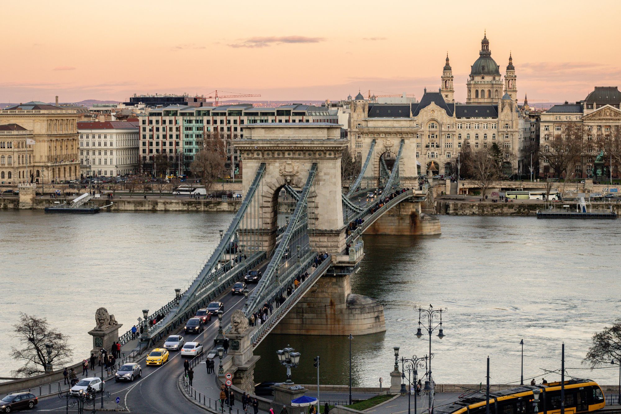The Chain Bridge over the Danube in Budapest at dusk, with St Stephen's Basilica behind.