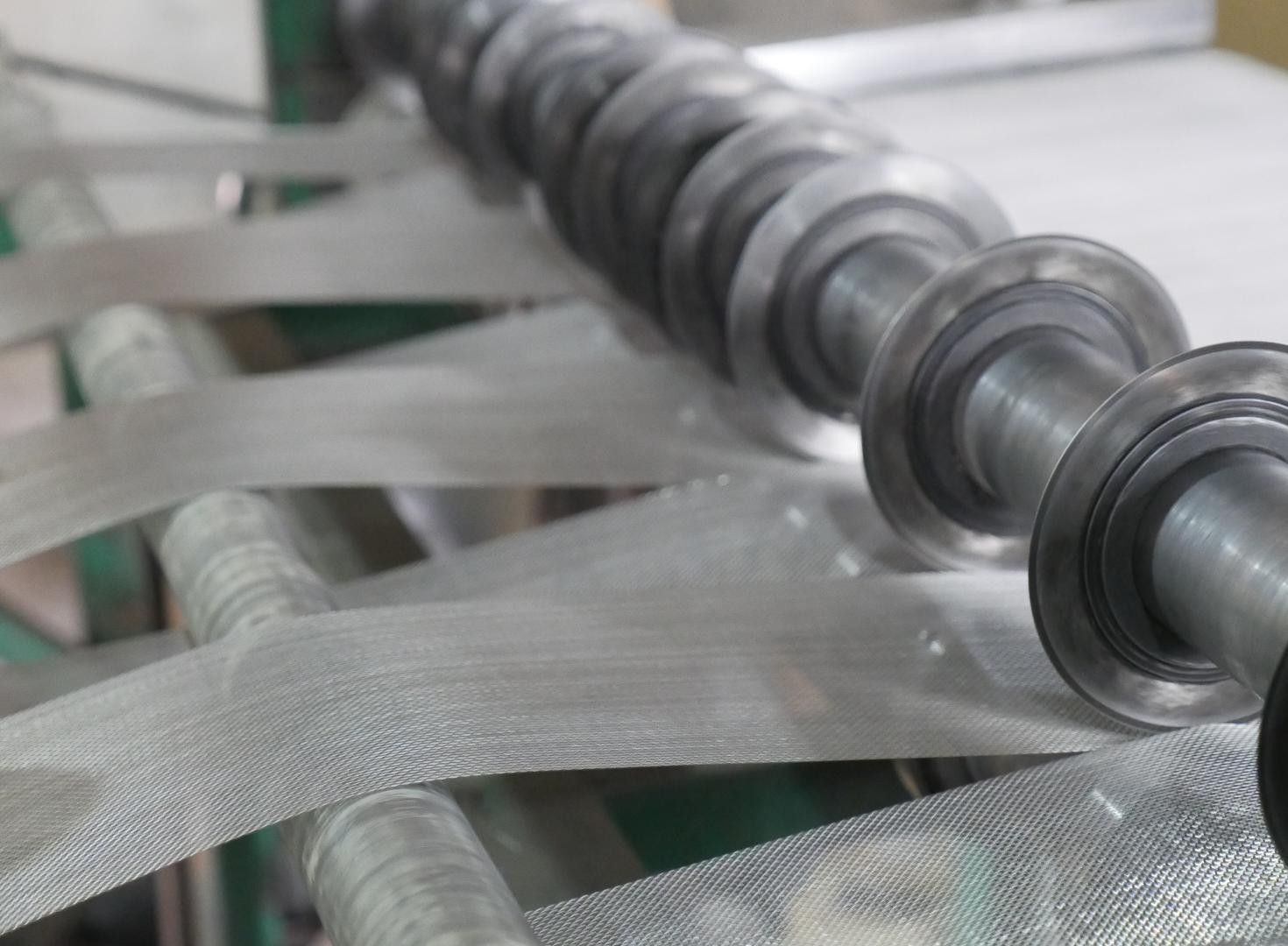 Close view of stainless steel woven wire mesh on rollers