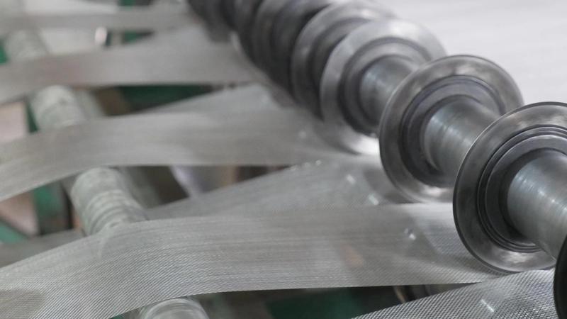 Close view of stainless steel woven wire mesh on rollers