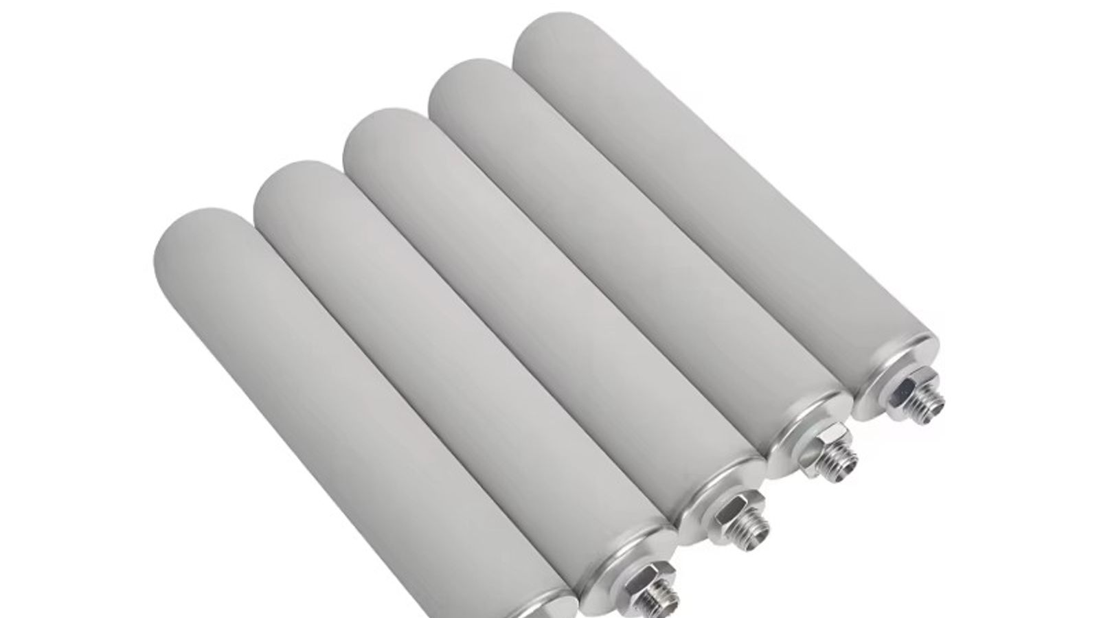 Rolls of stainless steel woven wire mesh and a cylindrical sintered filter cartridge on a factory workbench