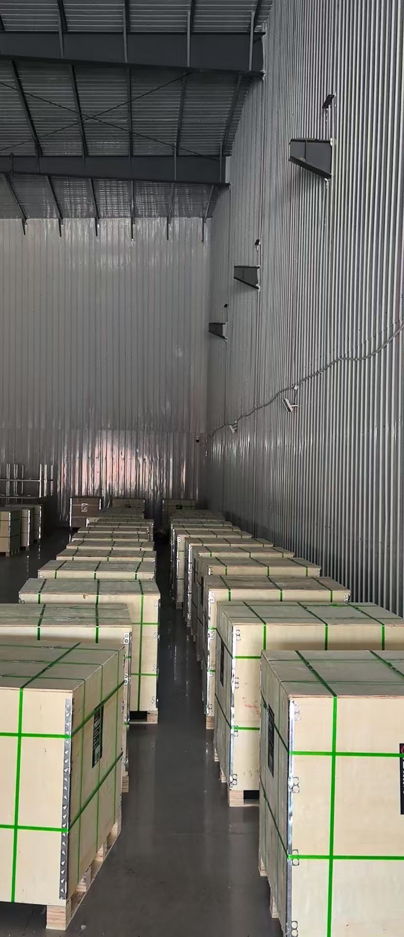Rows of export wooden crates with green strapping staged in the warehouse before shipment