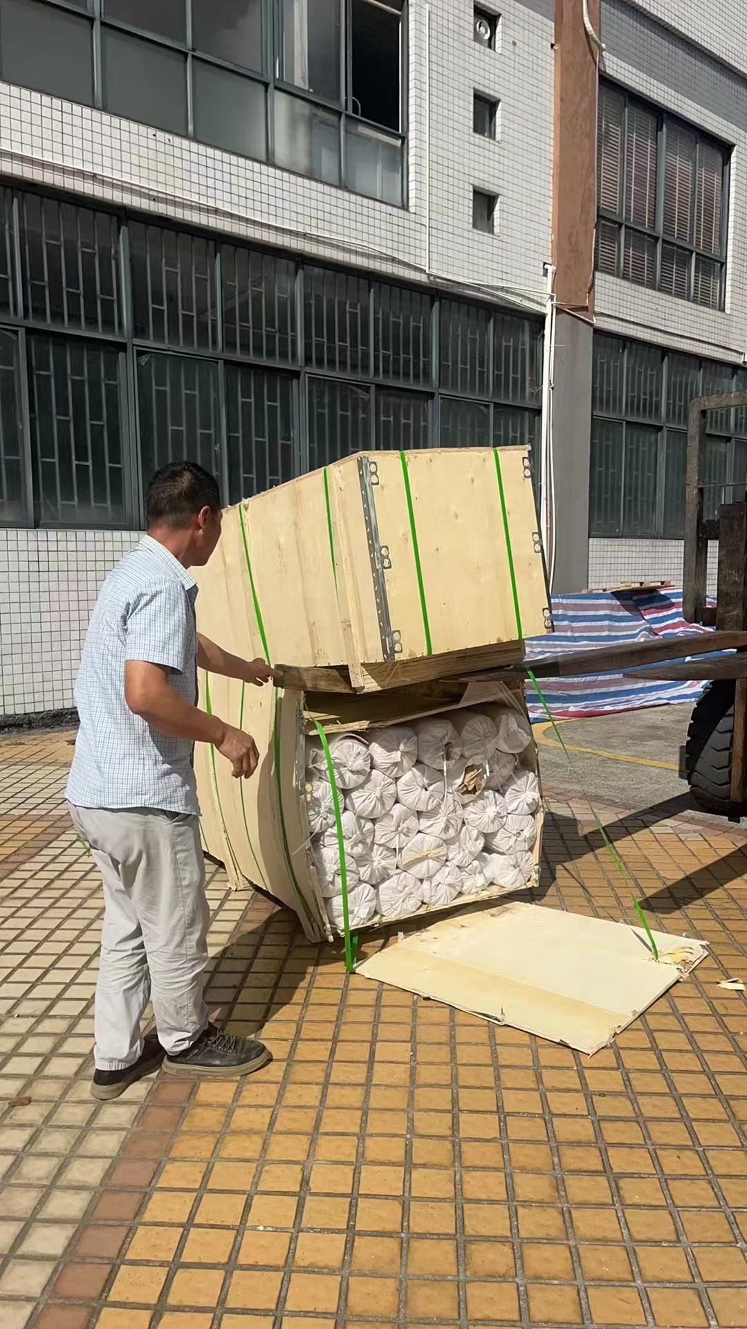 Forklift moving a wooden crate of stainless steel wire mesh rolls for export shipment