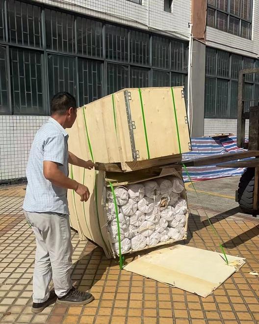Forklift moving a wooden crate of stainless steel wire mesh rolls for export shipment