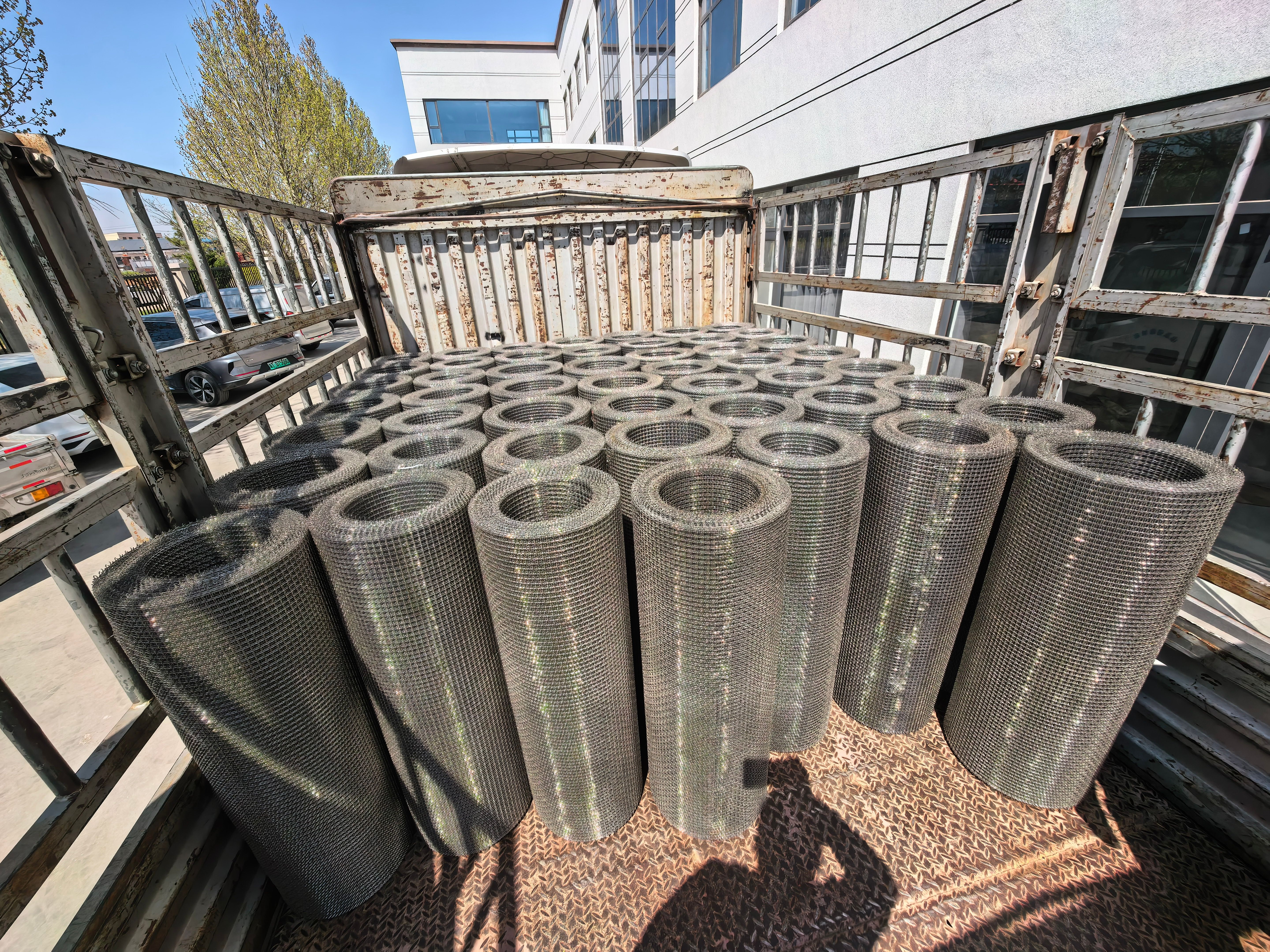 Bulk shipment of galvanized wire mesh rolls loaded on a truck at the factory yard