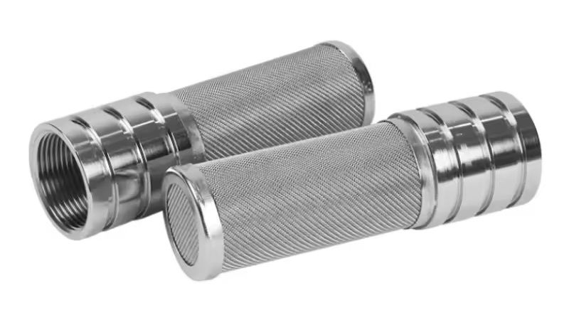 A quality inspector examining a welded stainless steel wire mesh filter assembly with a caliper, checking weld seams and dimensional tolerances