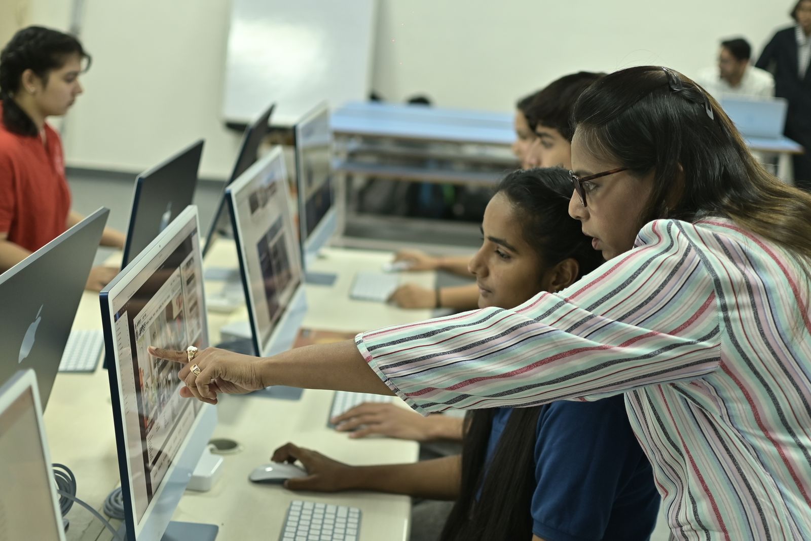 An Indian student working at a computer in a lab