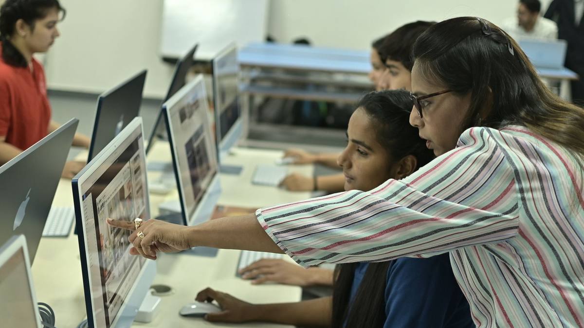 An Indian student working at a computer in a lab