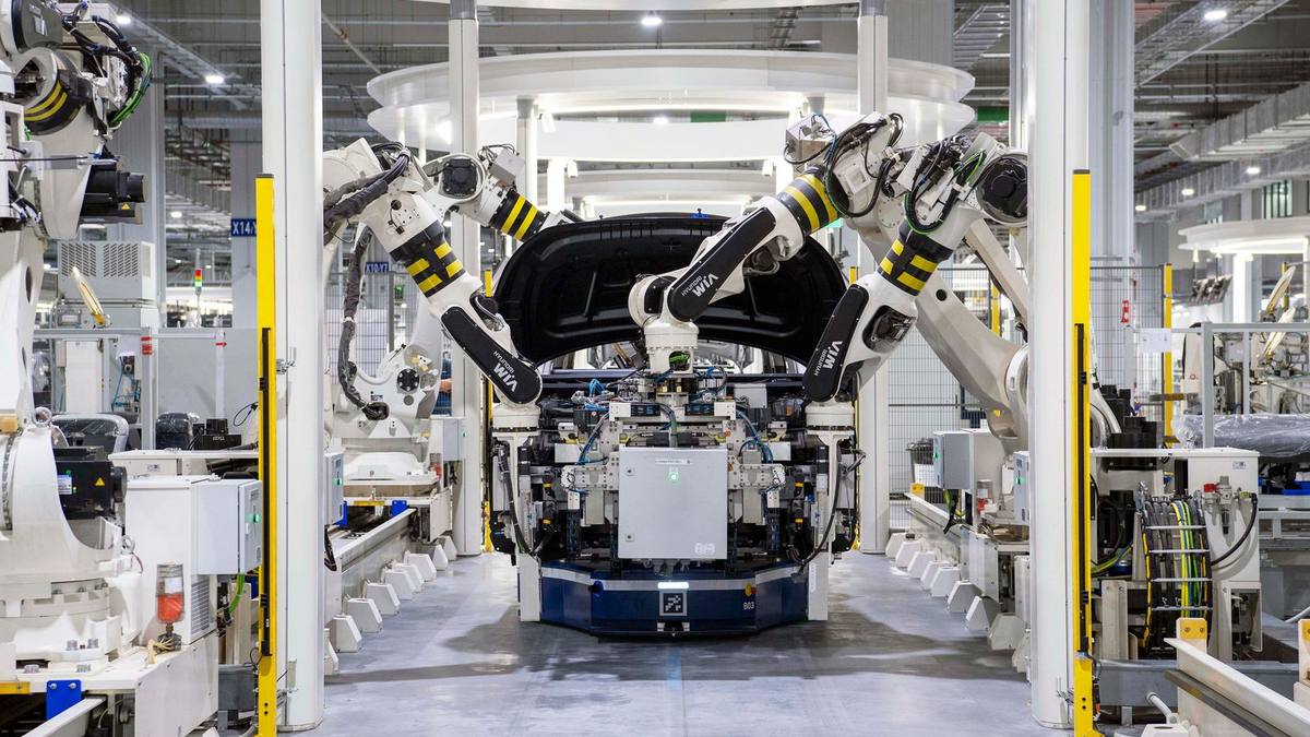 Robotic arms assembling a car on a factory line