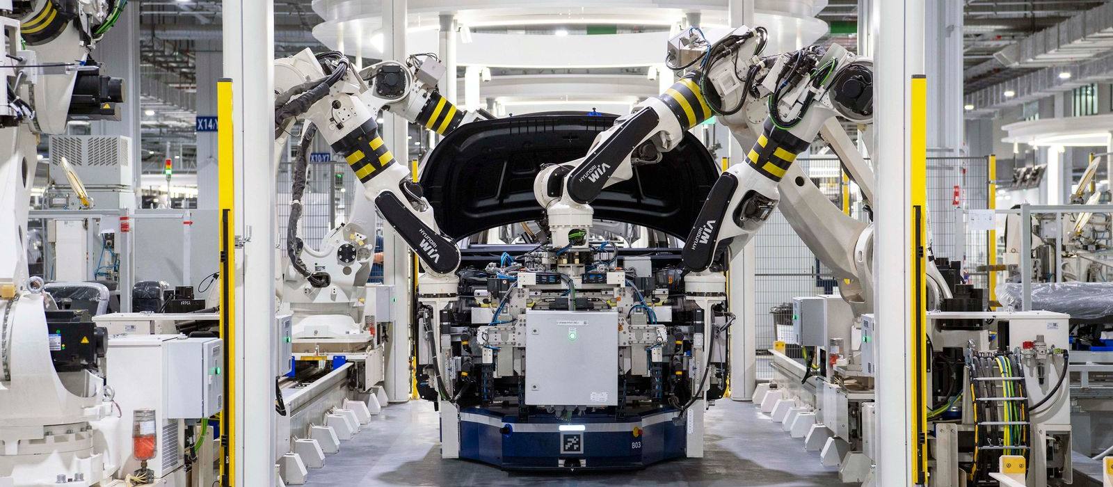 Robotic arms assembling a car on a factory line