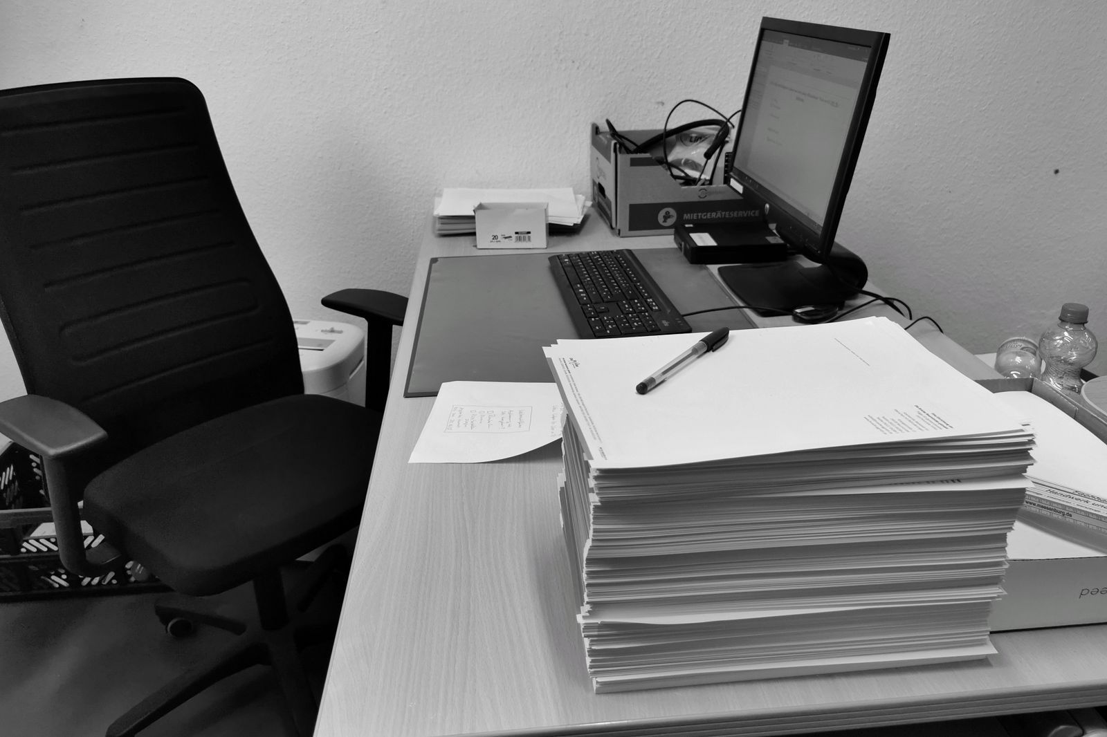 A desk cluttered with documents and files