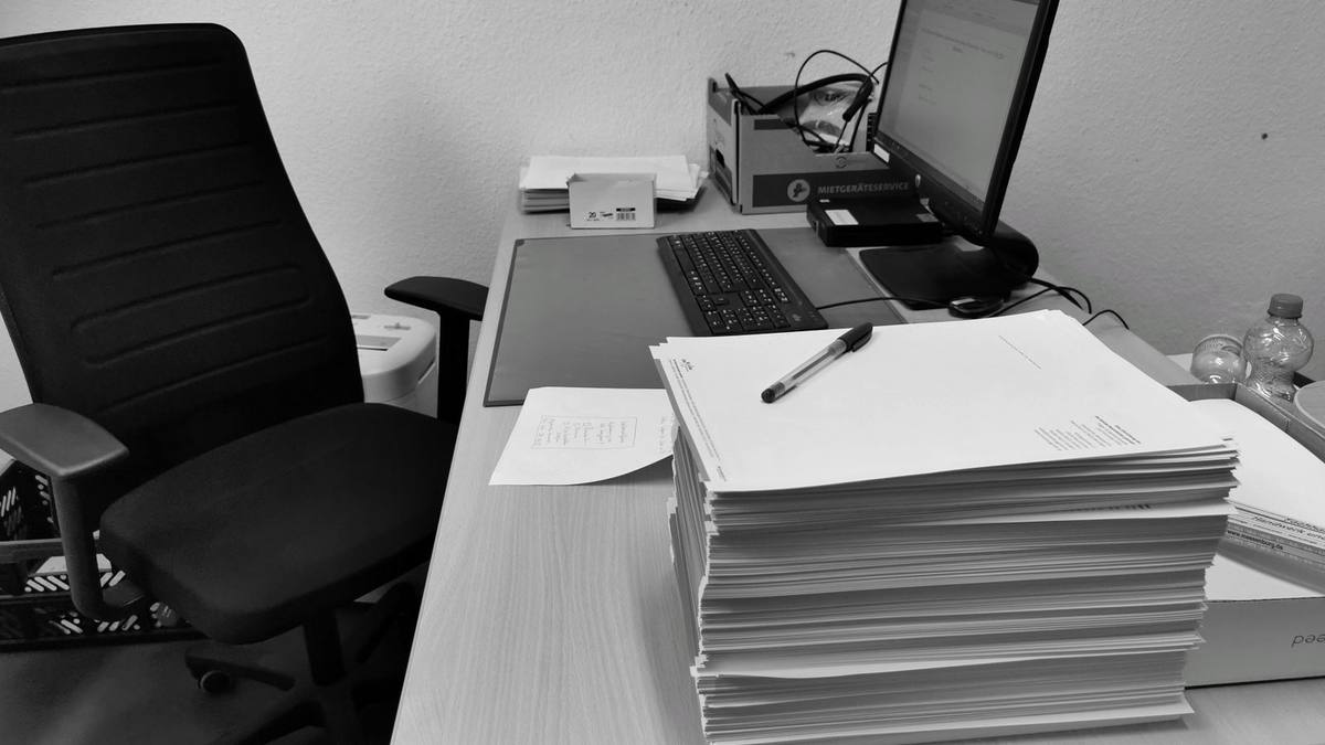 A desk cluttered with documents and files