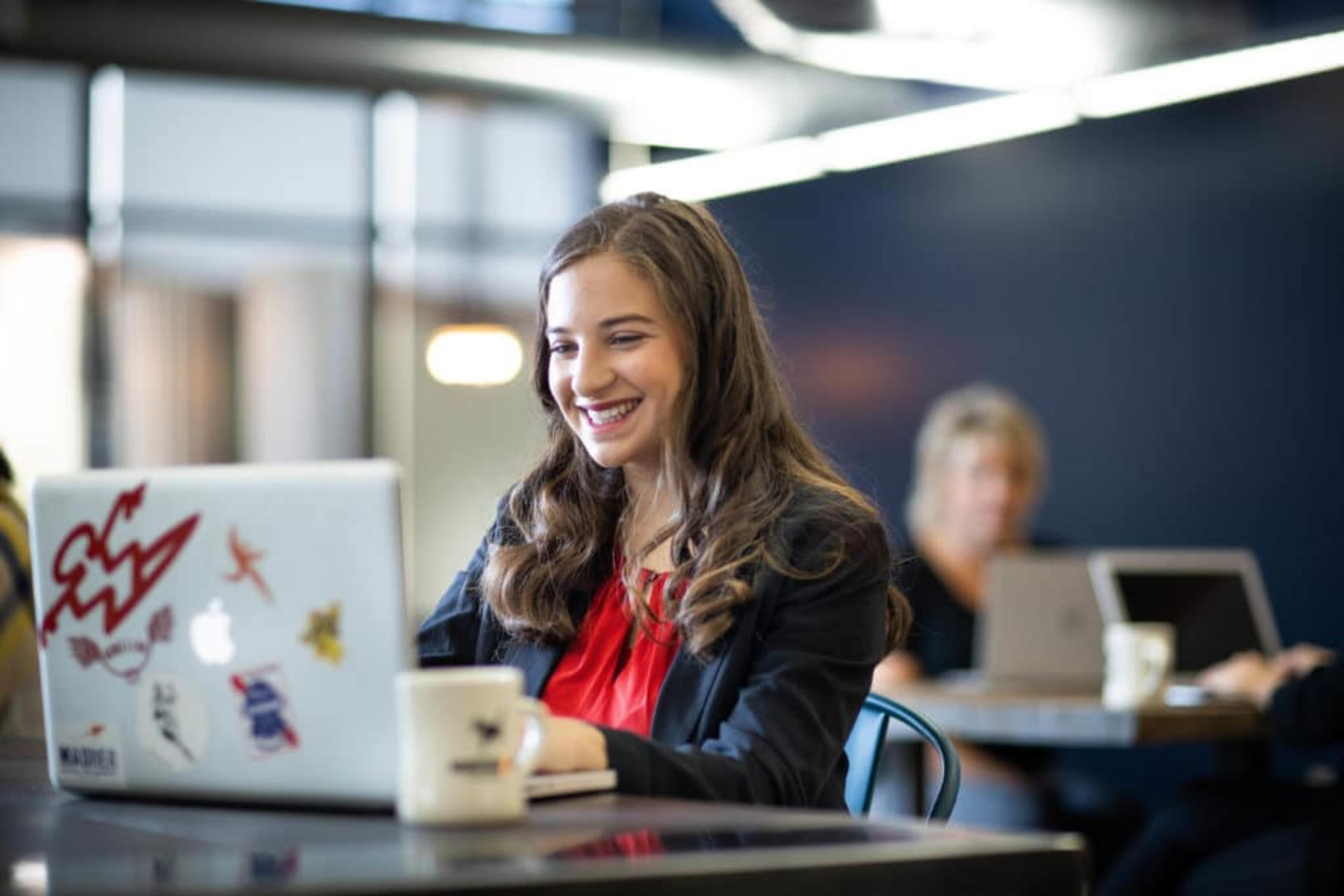 Smiling woman working at a hot desk at Workhorse Coworking